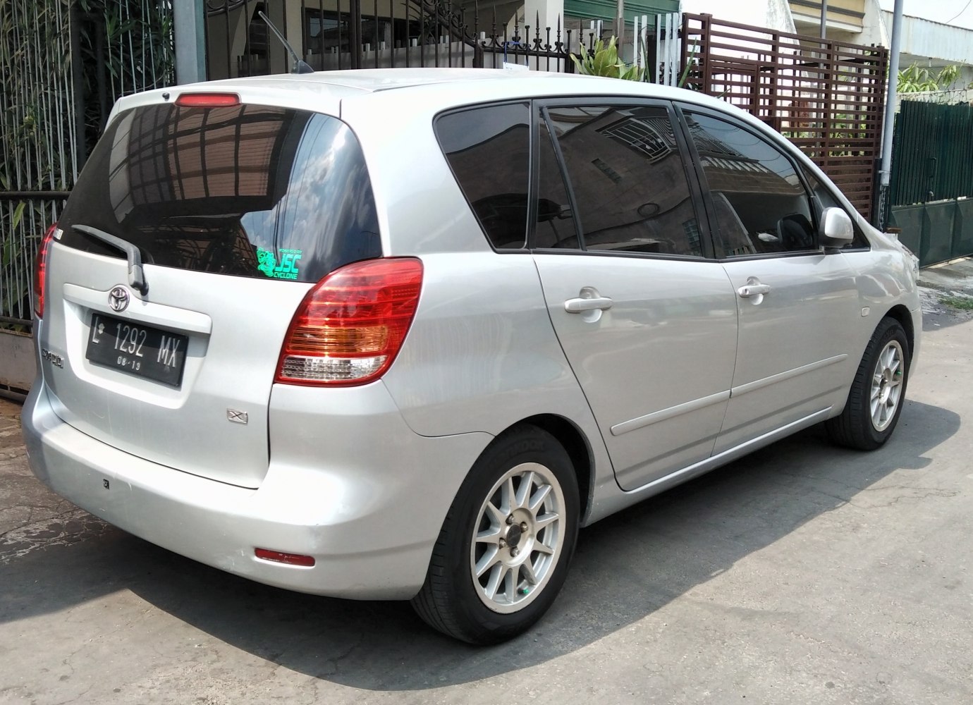 Rear and side view of a silver compact MPV with distinct taillights.