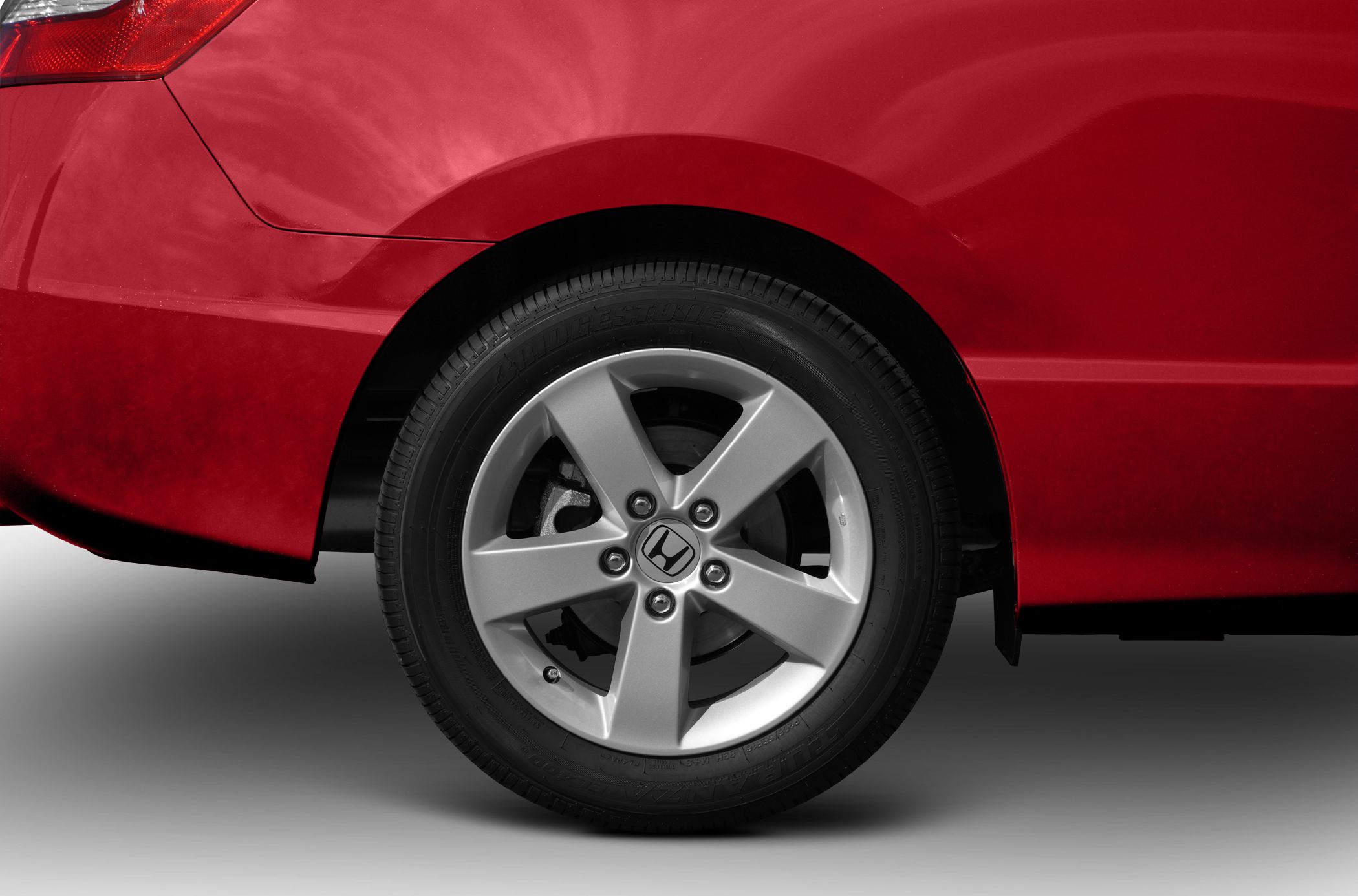 Close-up of rear wheel, alloy rim, and red fender.