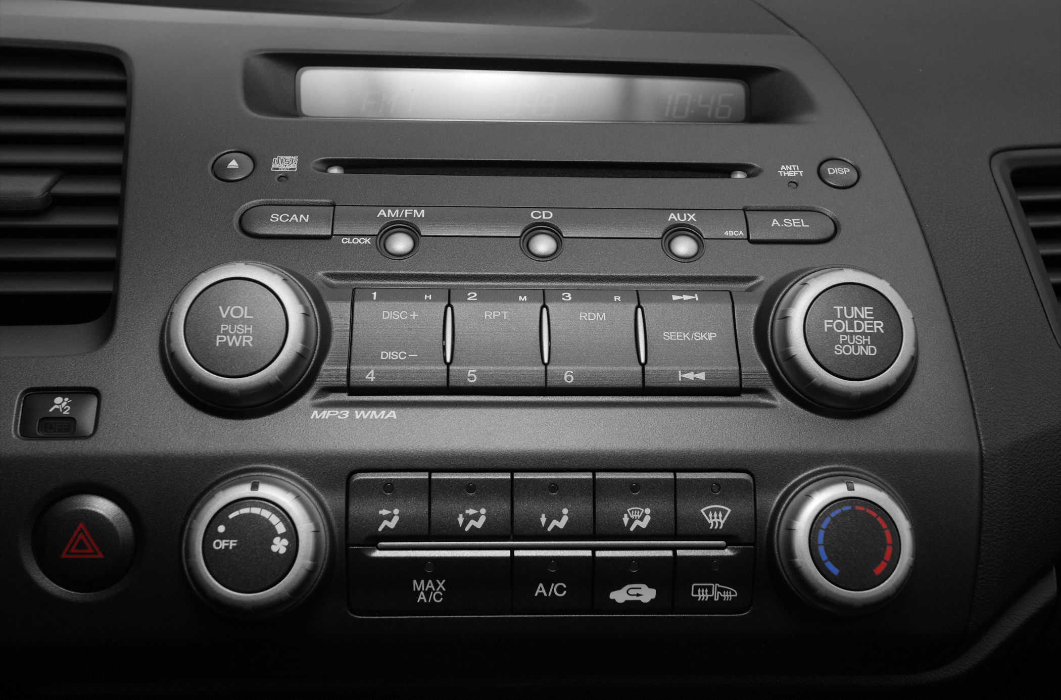 Close-up of car audio and climate control panel with buttons and knobs