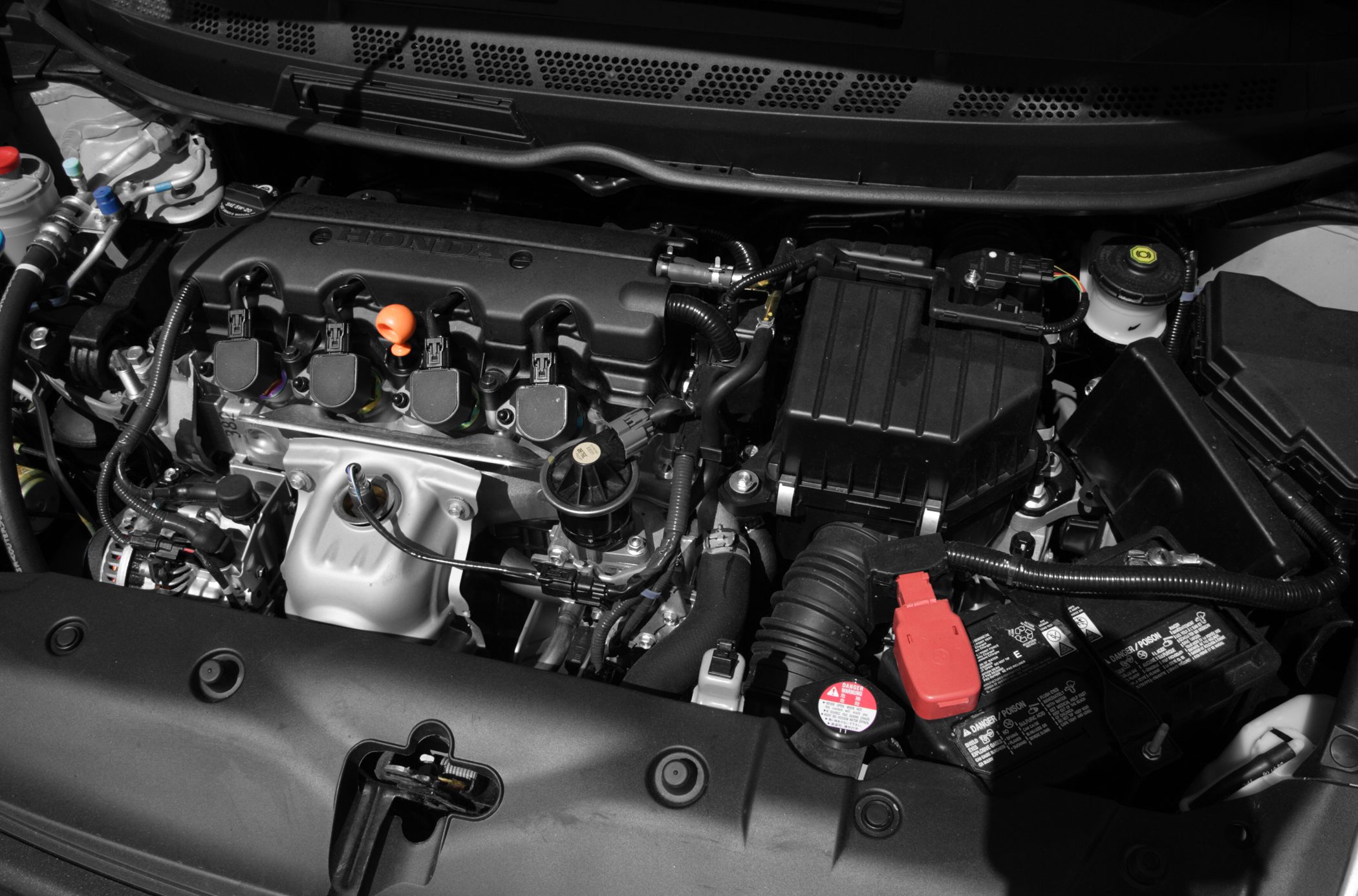 Close-up of engine bay with visible engine components and battery