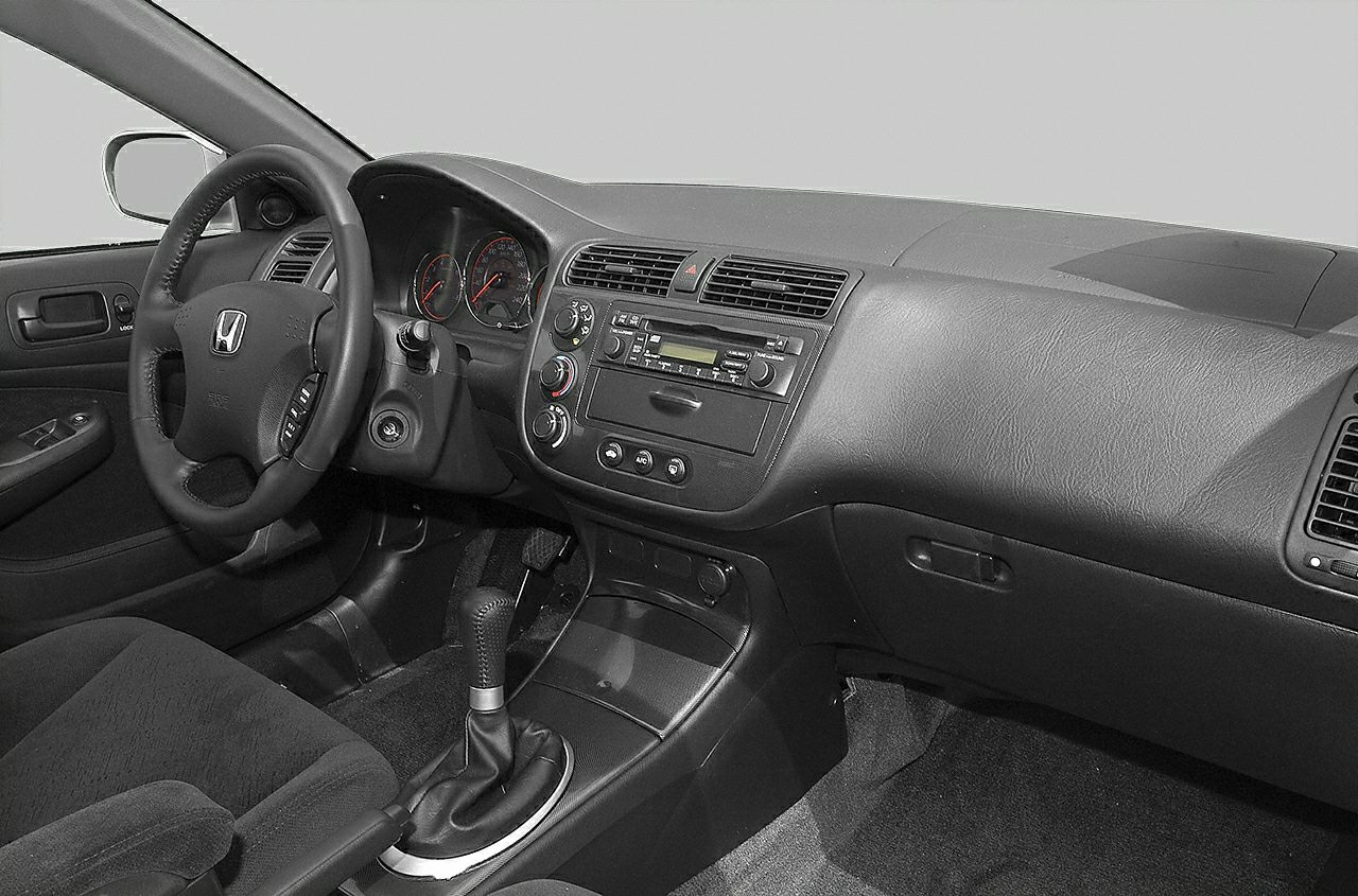 Dashboard, steering wheel, analog gauges, center console with manual gear shift