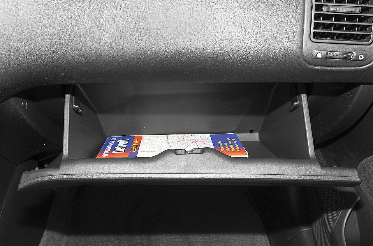 Open glove compartment with a map inside in a car interior
