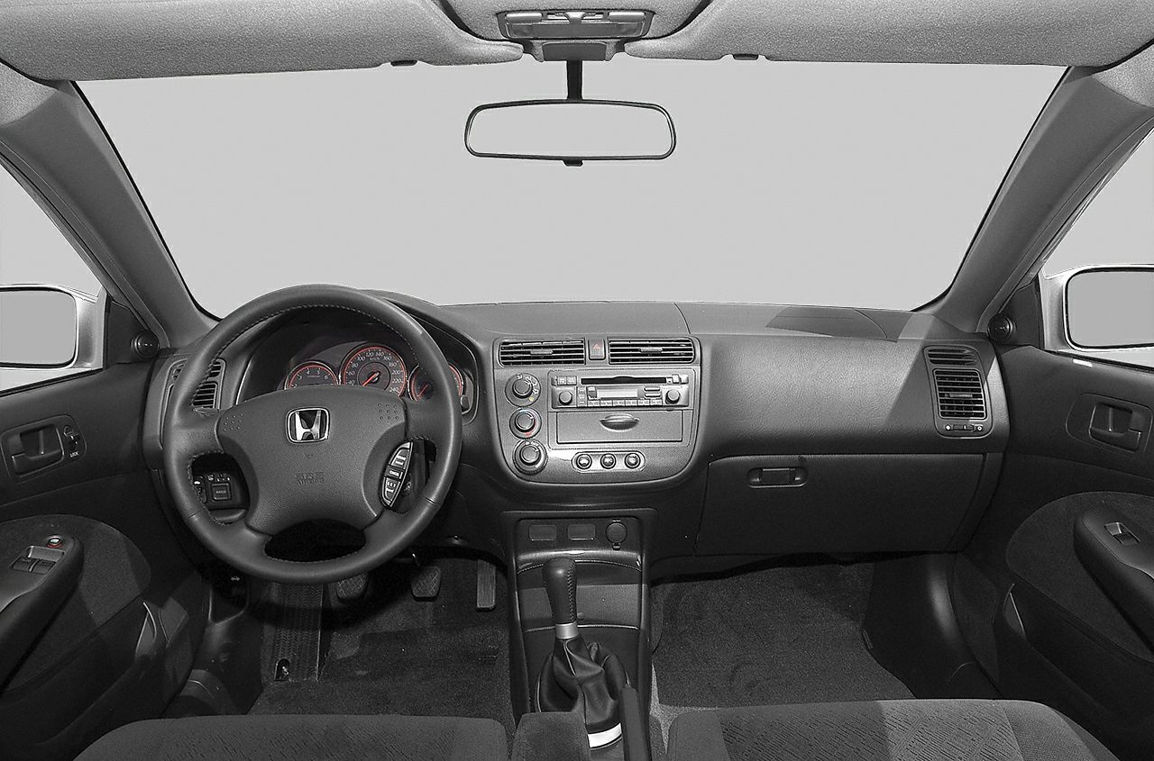 Car interior with steering wheel, dashboard, and center console.