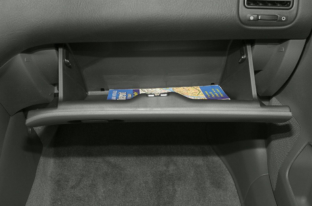 Open glove compartment with maps inside in car interior