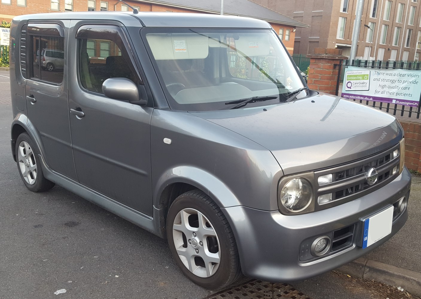 Boxy compact car with rounded headlights and front-side view