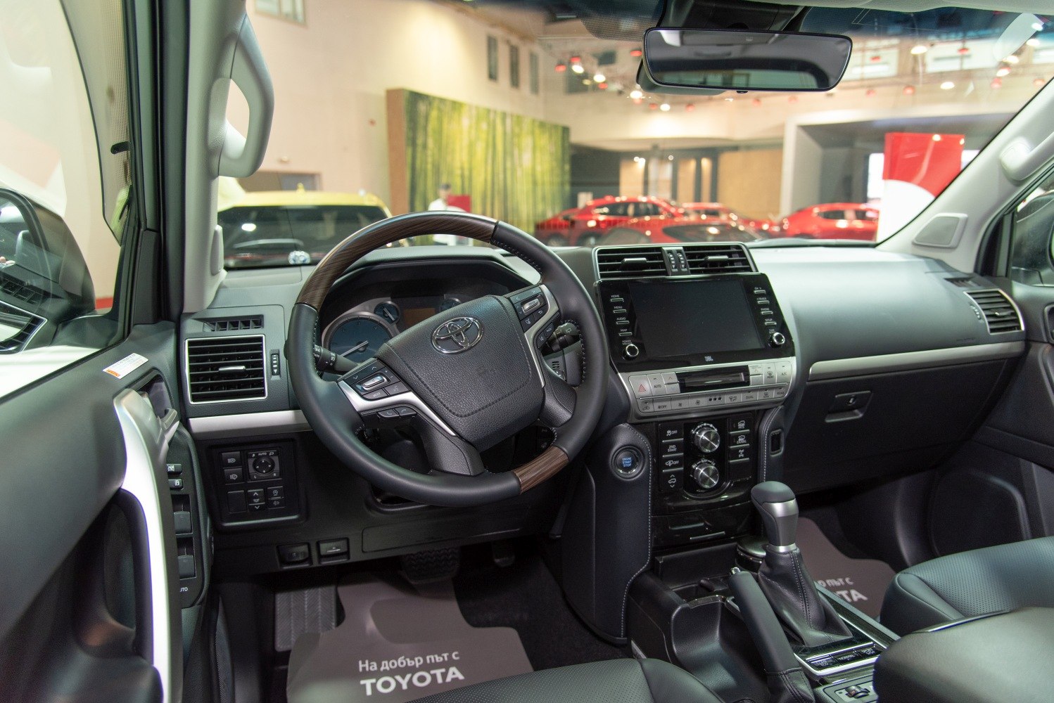 Toyota SUV interior with steering wheel, multimedia screen, and control panel
