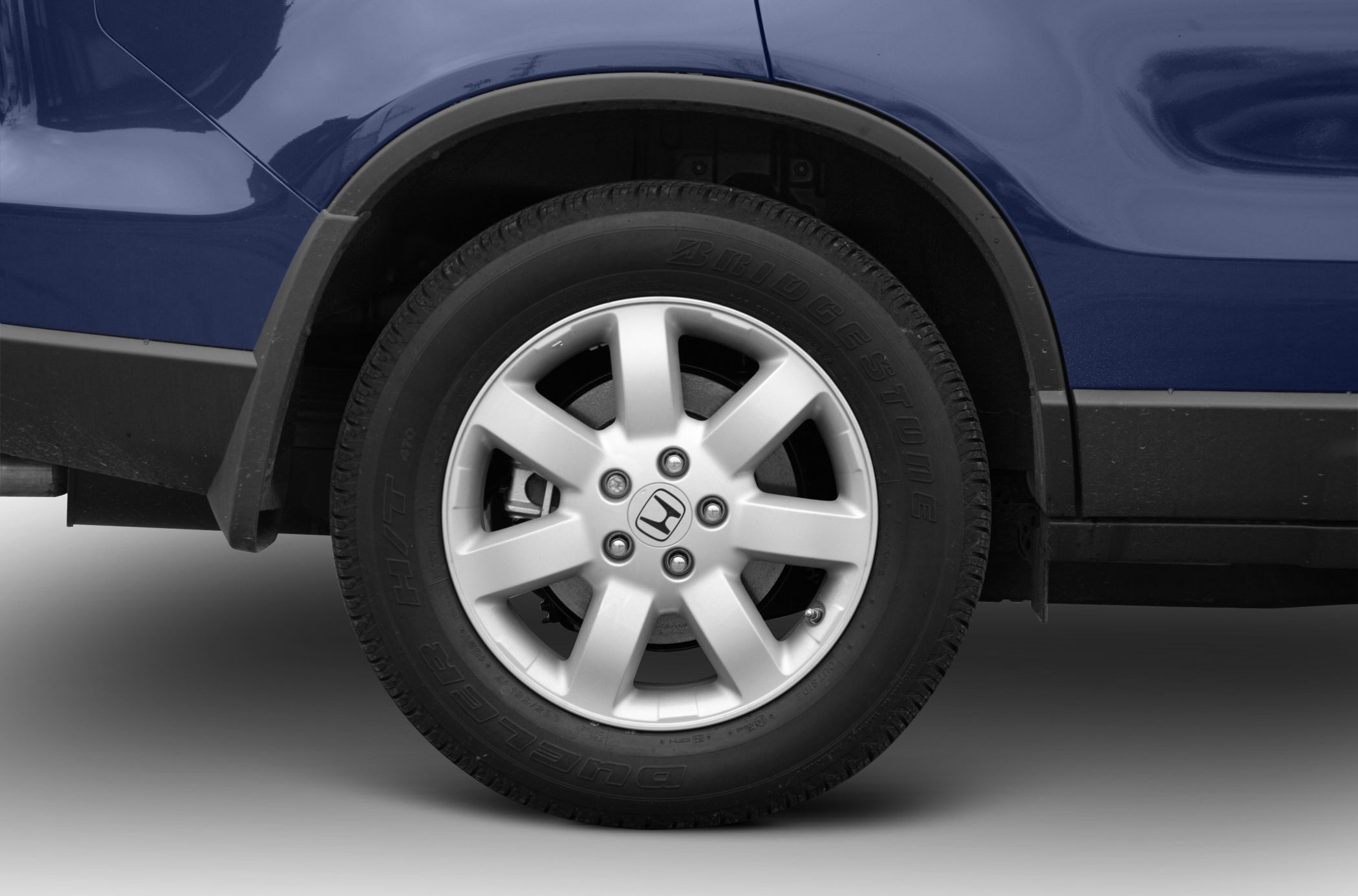 Alloy wheel and Bridgestone Dueler H/T tire on blue vehicle body