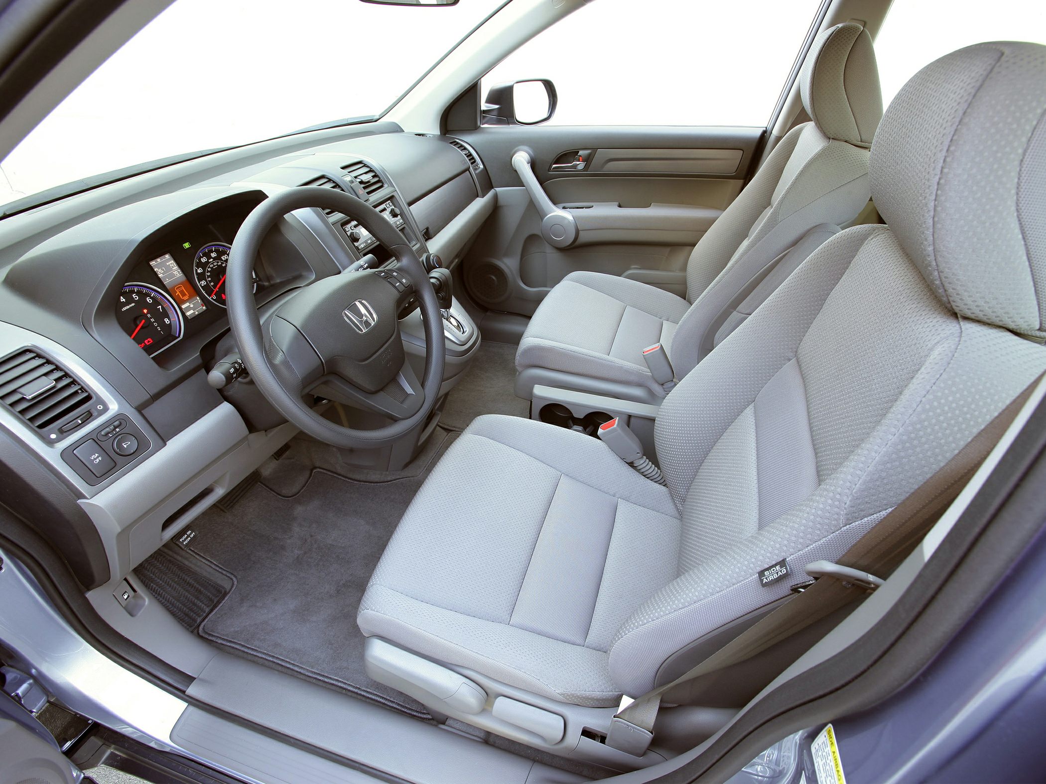 Car interior with dashboard and front fabric seats in light gray