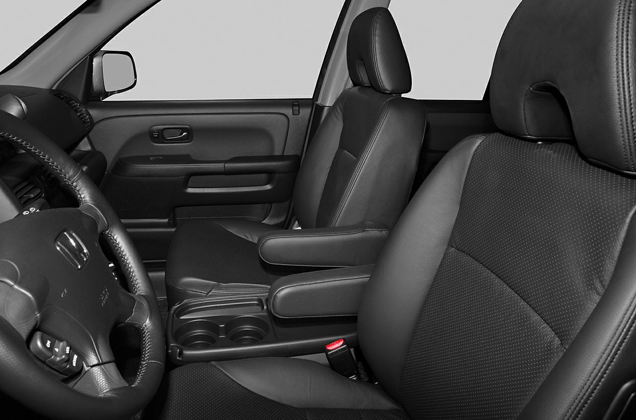 Black front seats with armrests and steering wheel close-up.