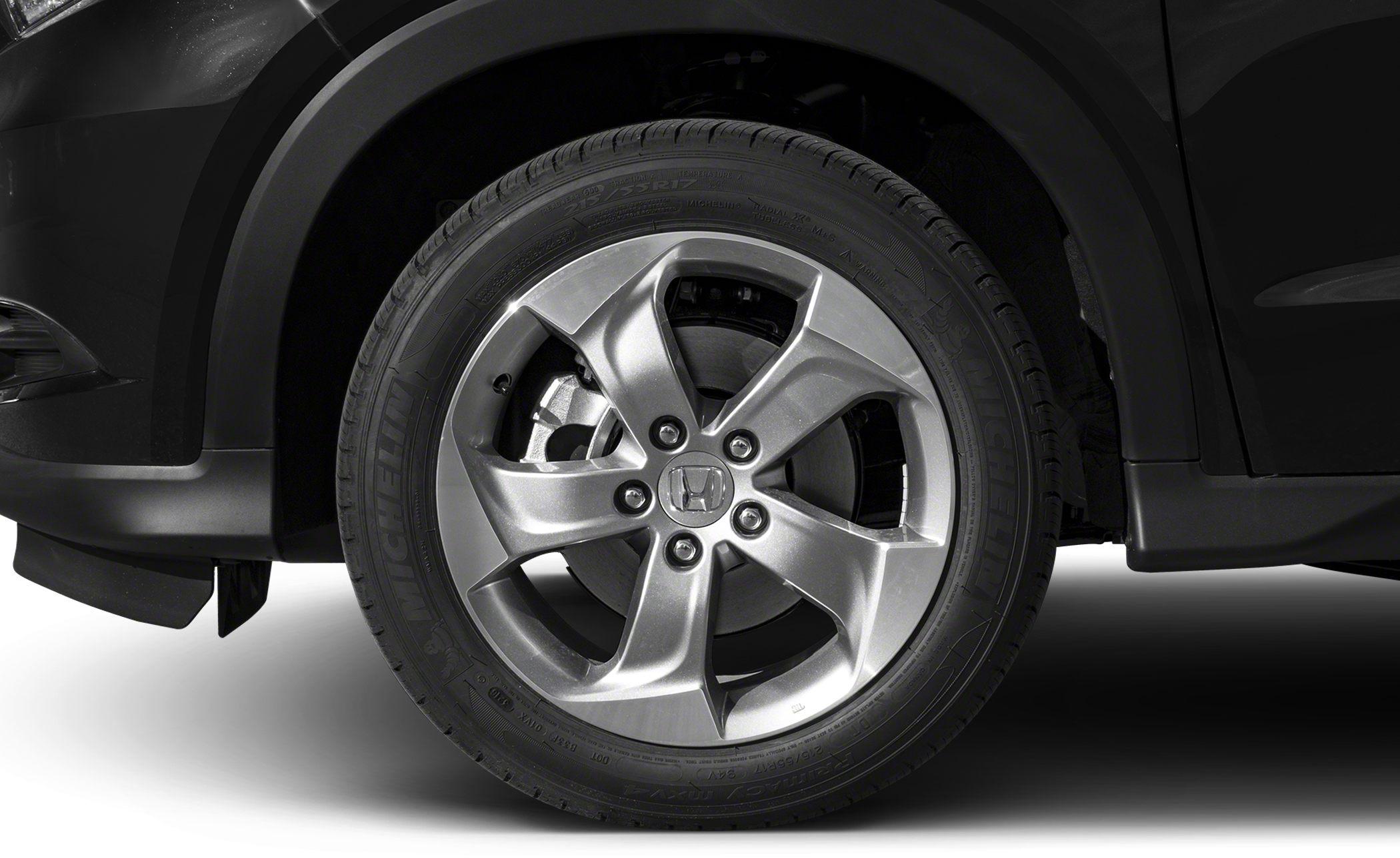 Close-up of 5-spoke alloy wheel and tire mounted on vehicle.