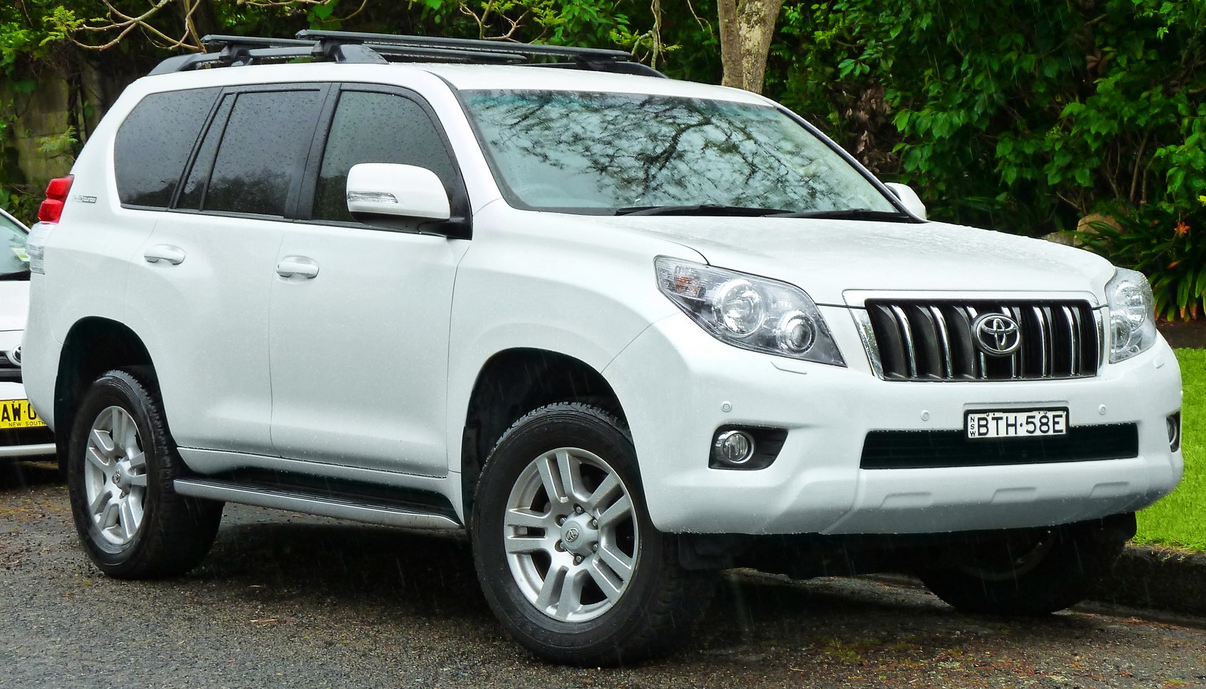 White SUV front-side view with prominent grille and alloy wheels