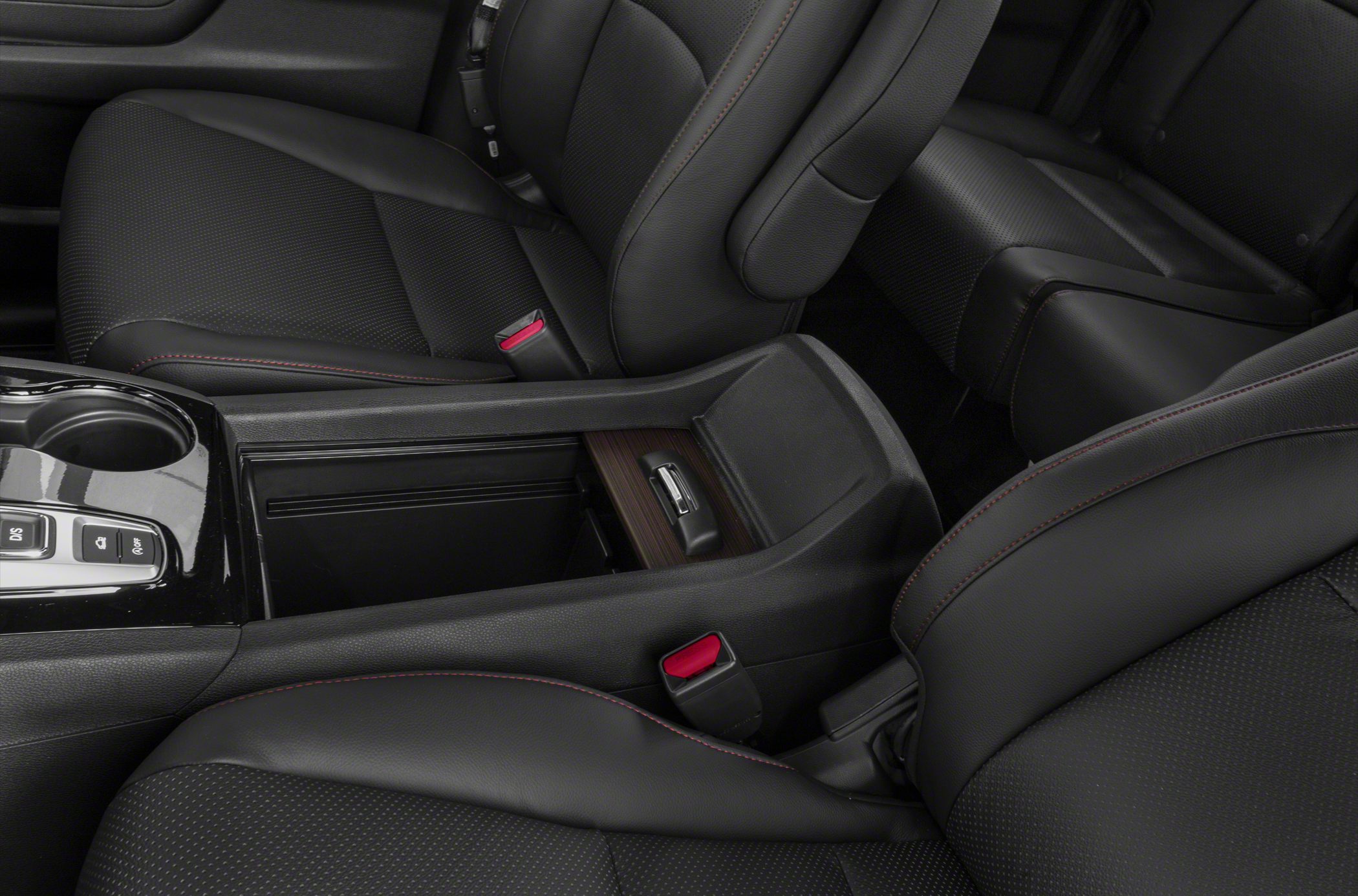 Black leather seats with red stitching and open center console storage.
