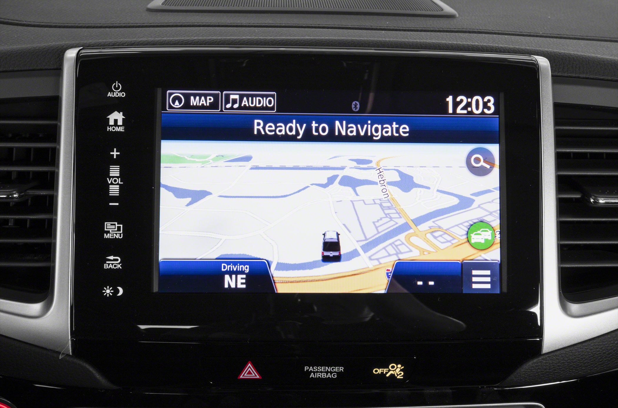 In-dash touchscreen navigation system with map display and control buttons