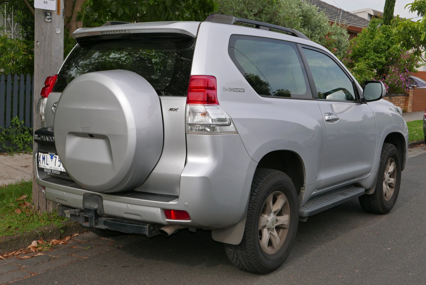 SUV rear with spare tire cover, side steps, and clear rear lights