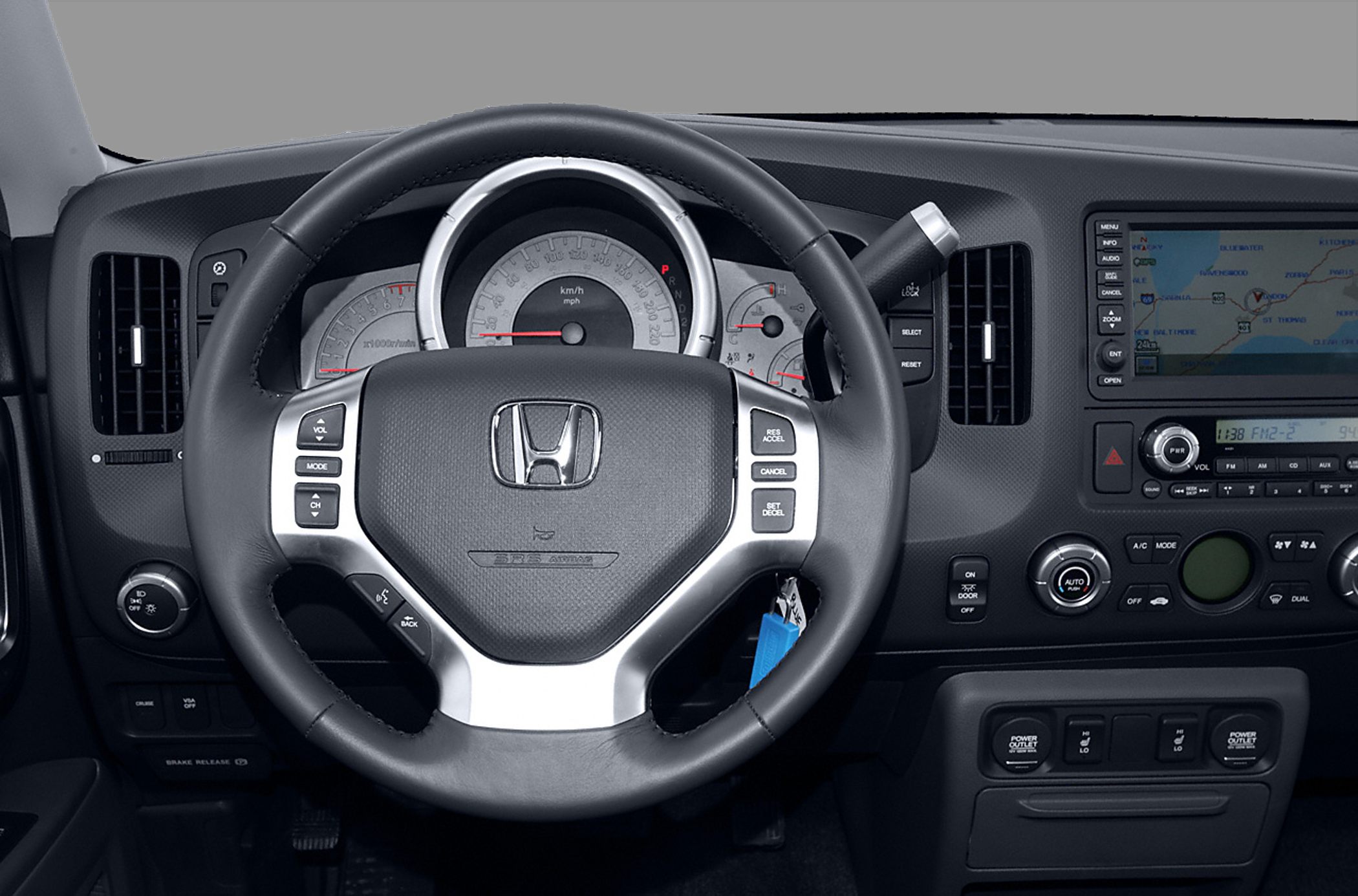 Steering wheel with control buttons and detailed dashboard with navigation system.