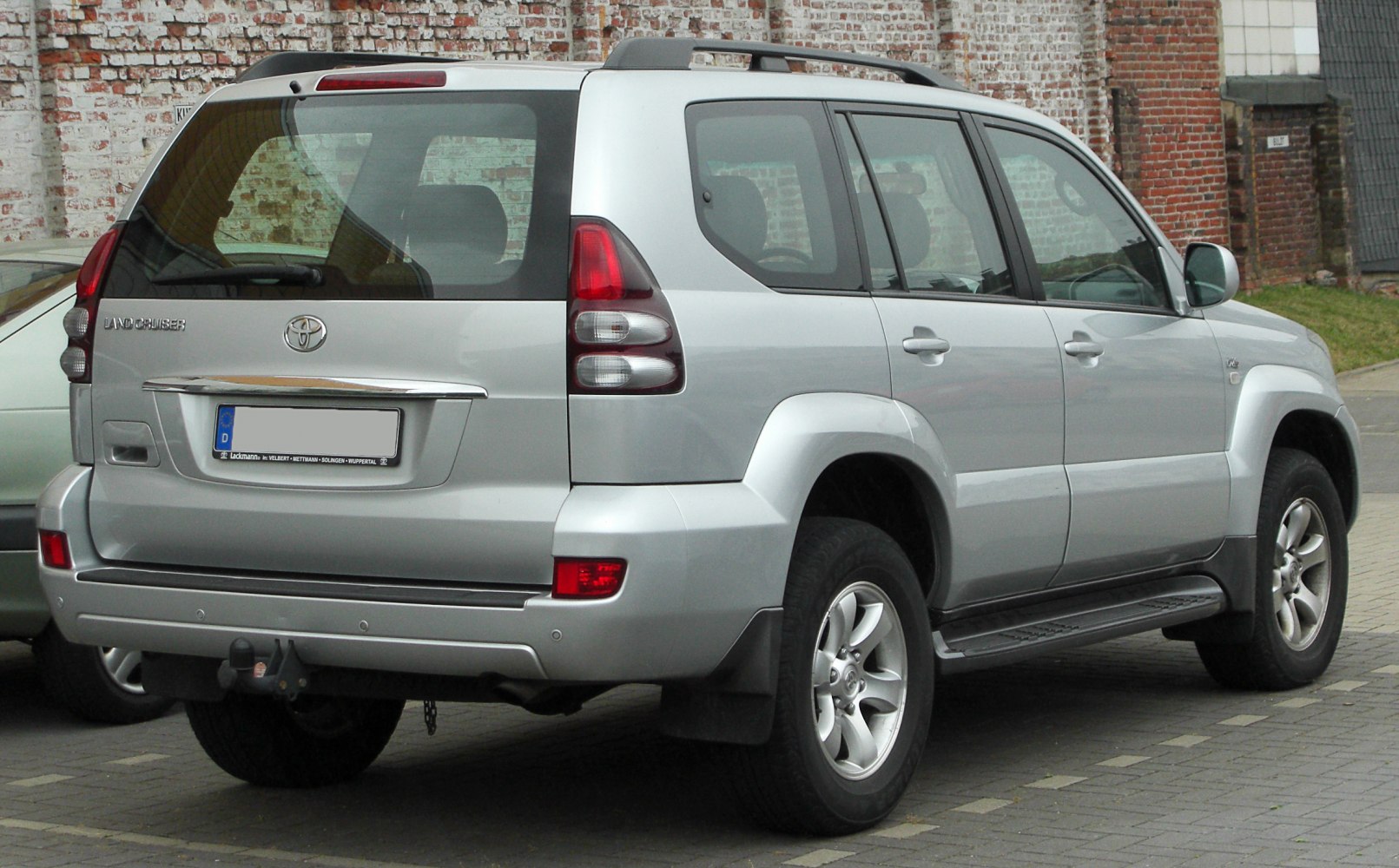 Rear view of an SUV with taillights, rear window, and tow hitch