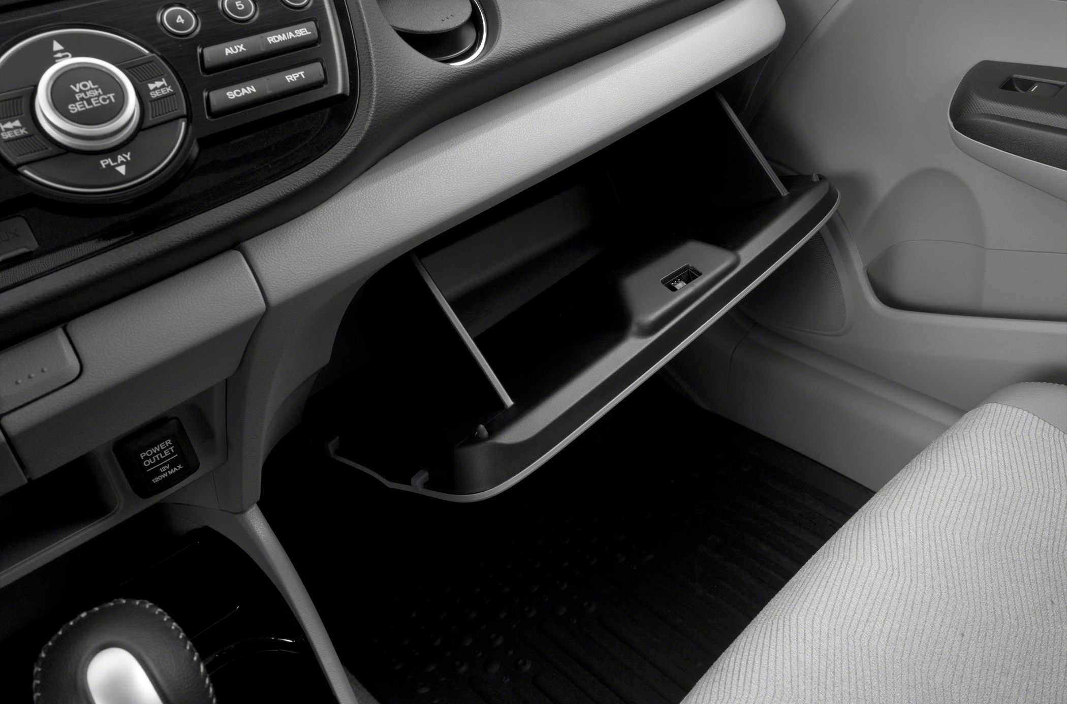 Open glove box and car audio control panel with volume selector knob