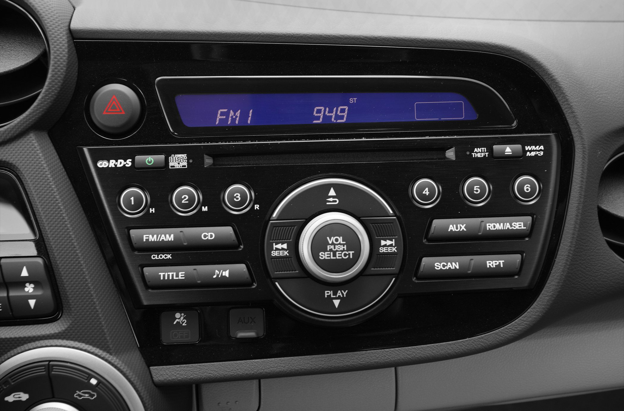 Car audio system with FM display, CD player, volume, and control buttons.