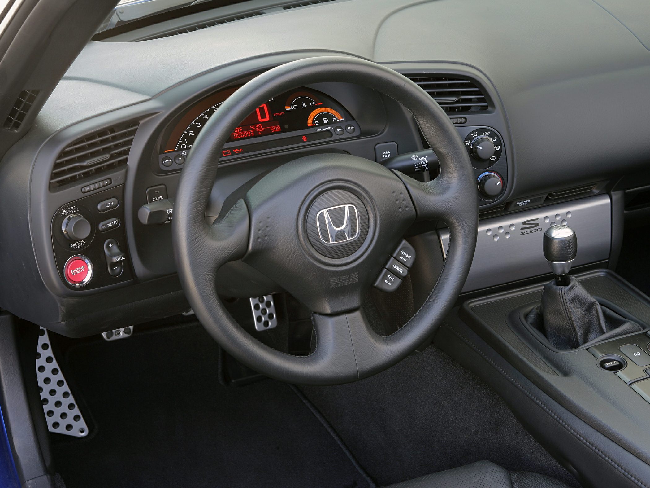 Dashboard with digital instrument cluster, multifunction steering wheel, and manual gear shifter