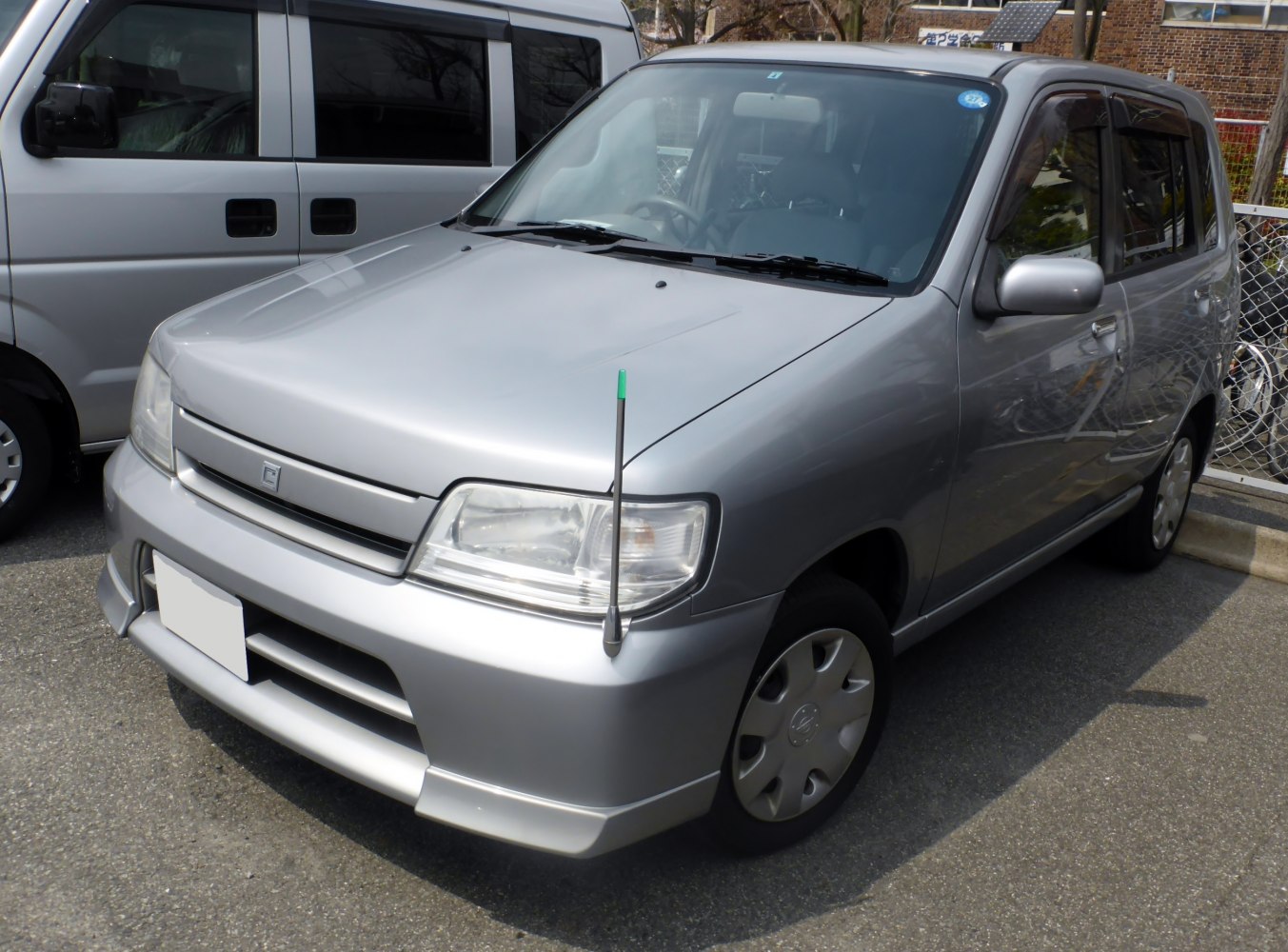 Silver compact hatchback with front fender antenna and clear headlights