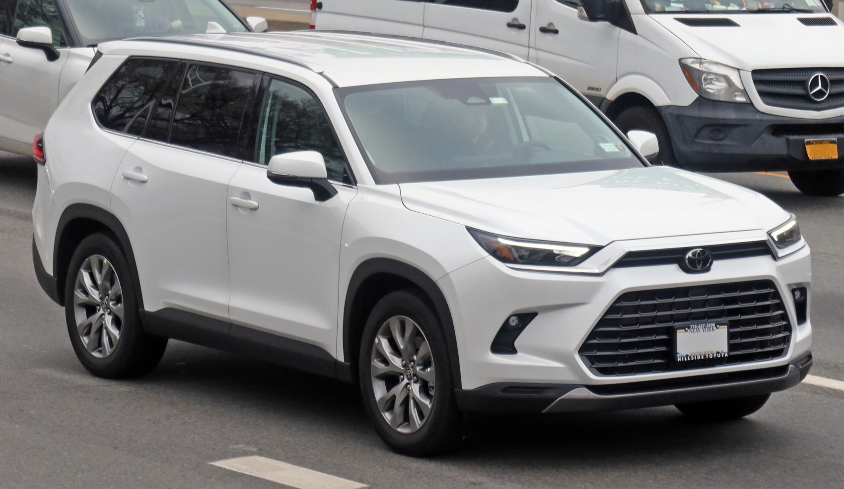 Front angle with sharp LED headlights and large grille on white SUV