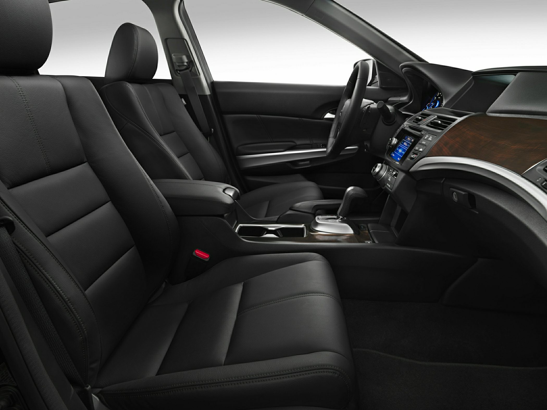 Black leather seats and wood trim dashboard in car interior