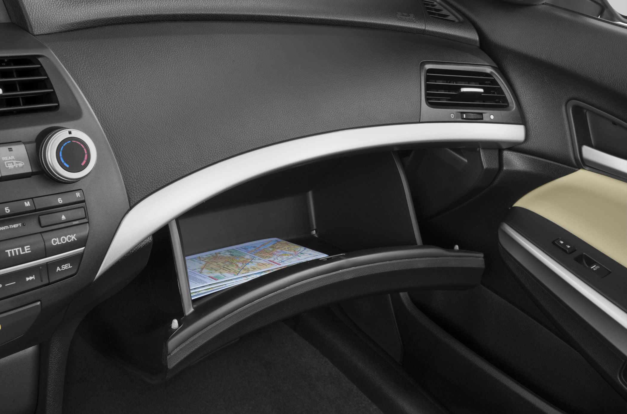 Open glove compartment with maps inside and dashboard climate controls