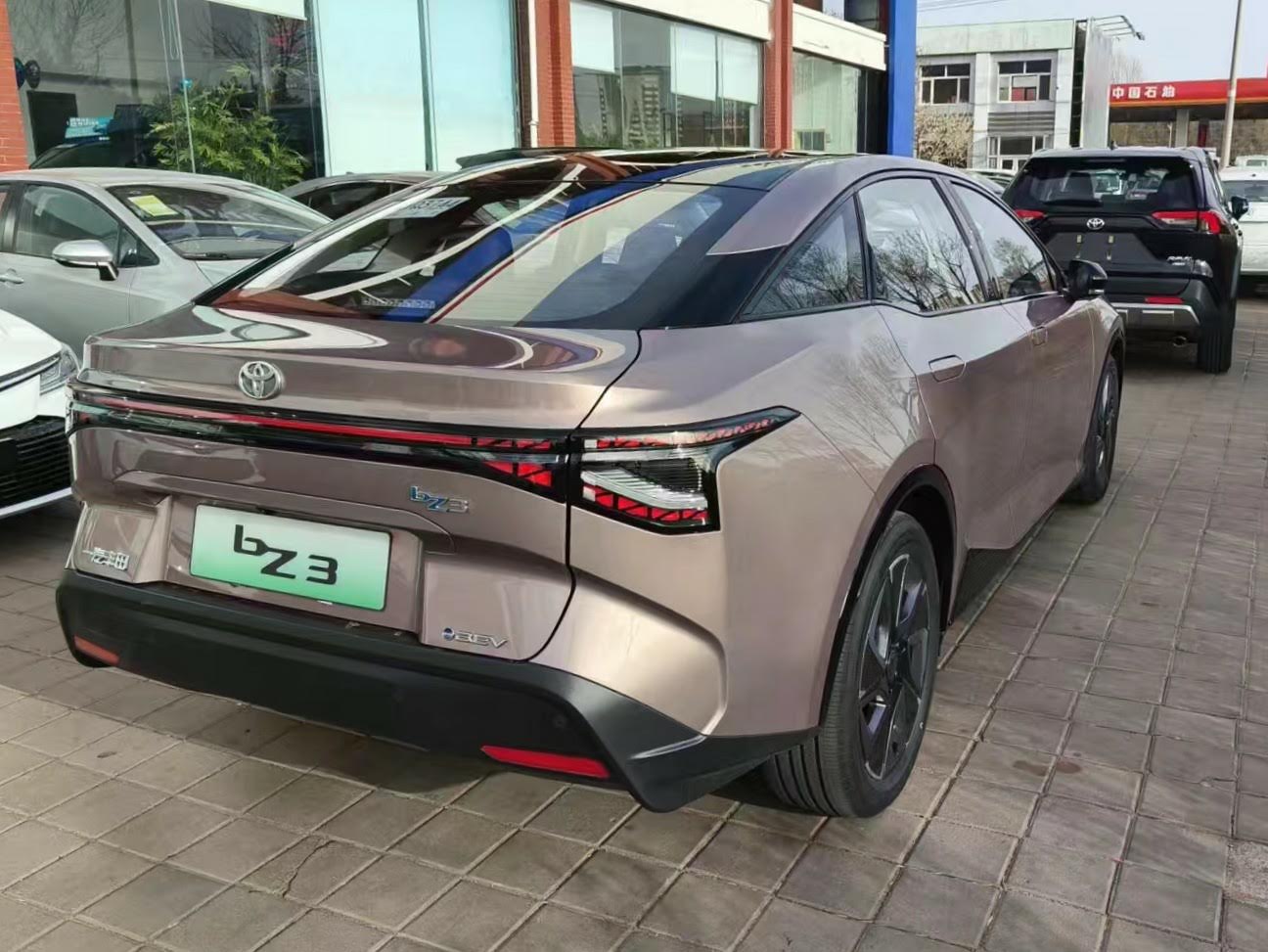 Rear view of electric SUV with continuous LED tail light and sculpted rear design.