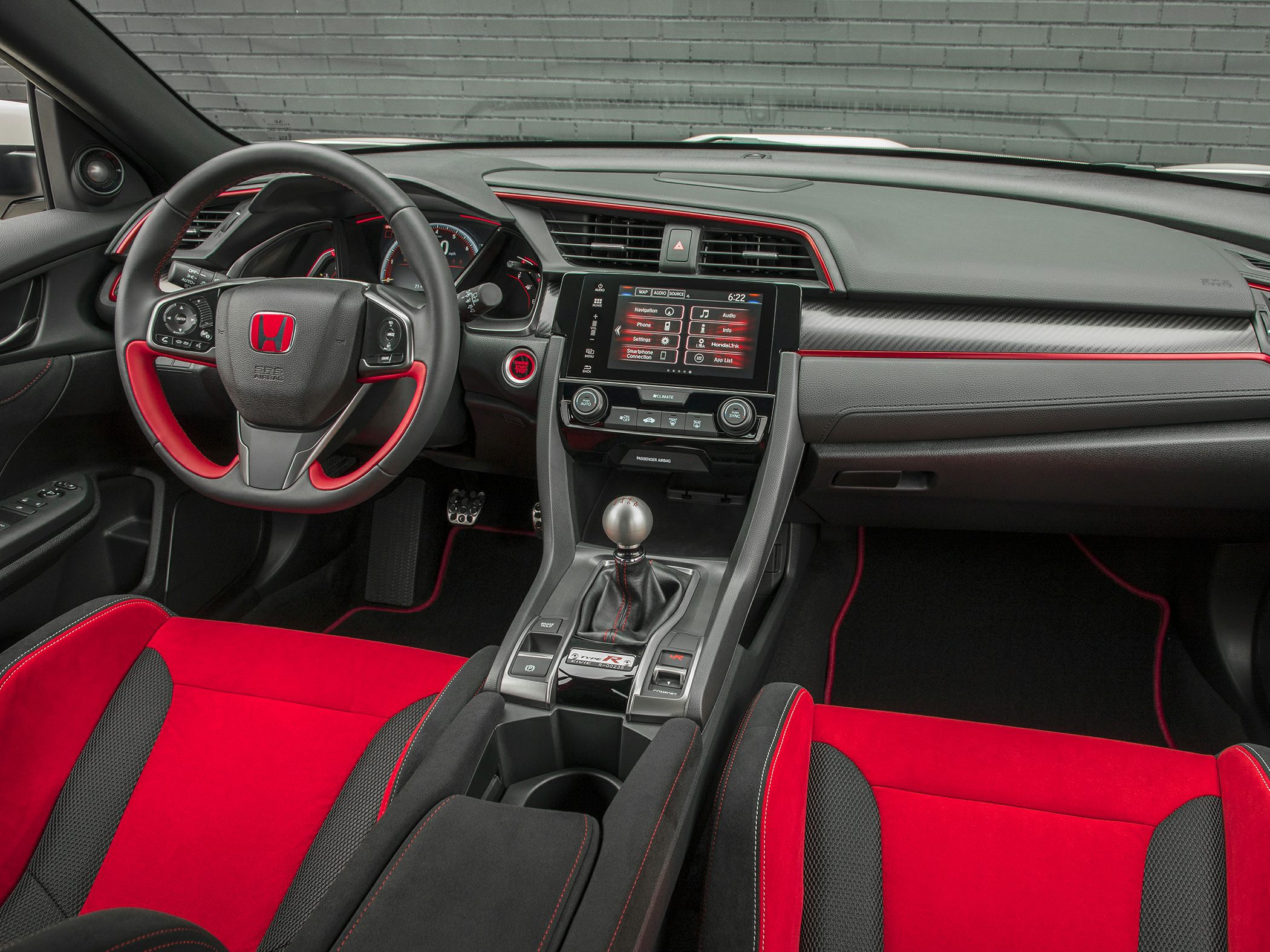 Sporty interior with red-accented steering and metal manual shift knob