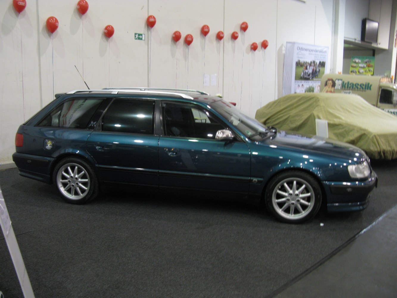 Dark green station wagon with alloy wheels and roof rails