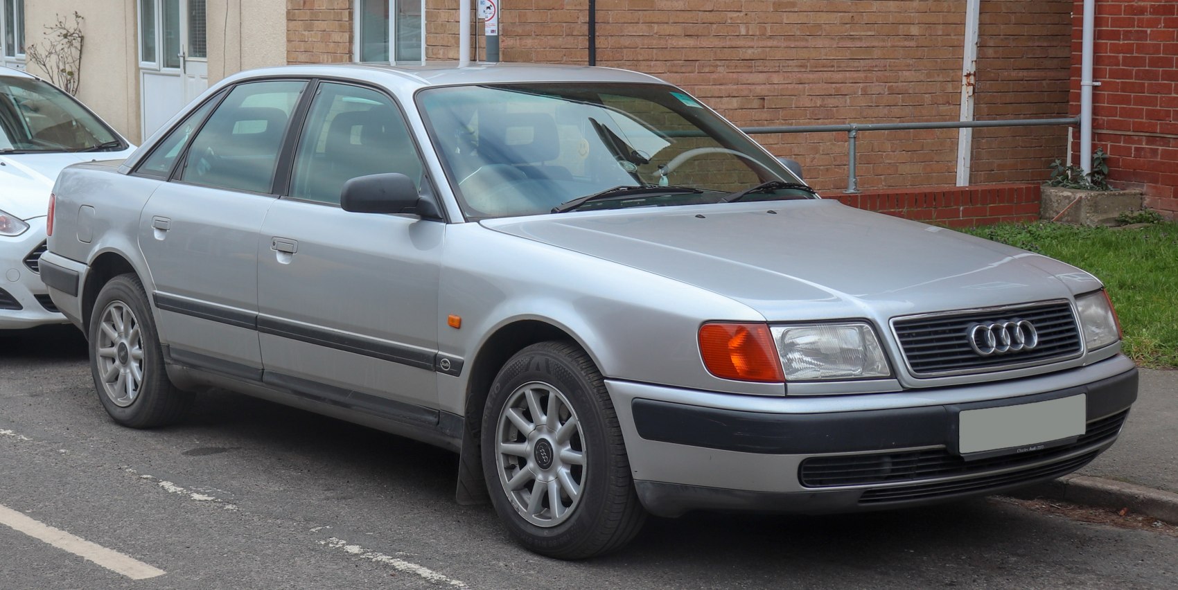 Silver sedan with distinctive headlights and grille, front side view.