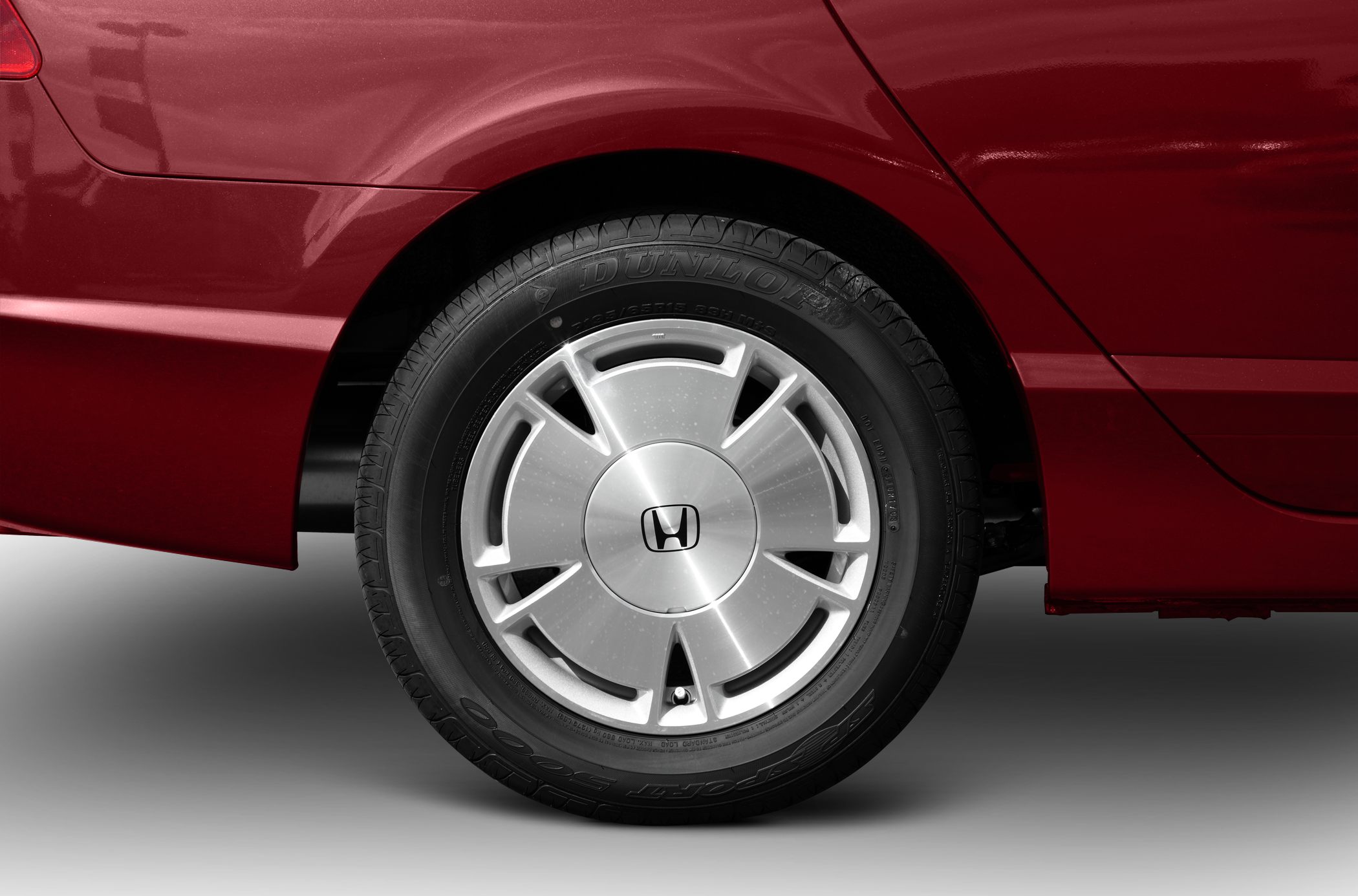 Rear wheel with alloy rim and Dunlop tire on red car body