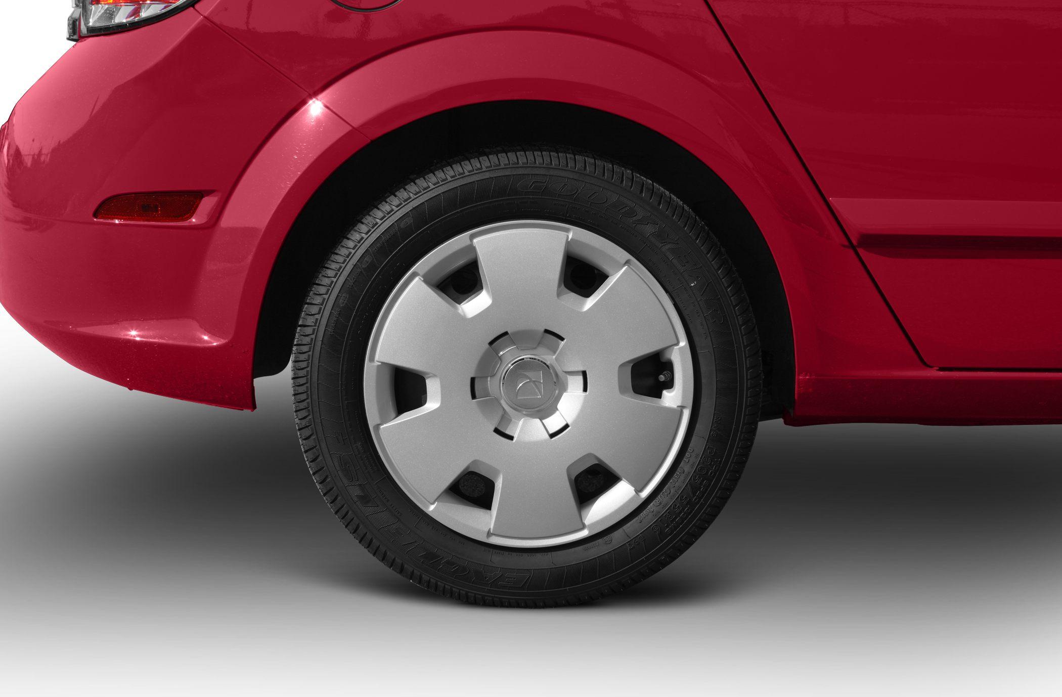 Close-up of rear wheel with silver hubcap and Goodyear tire.