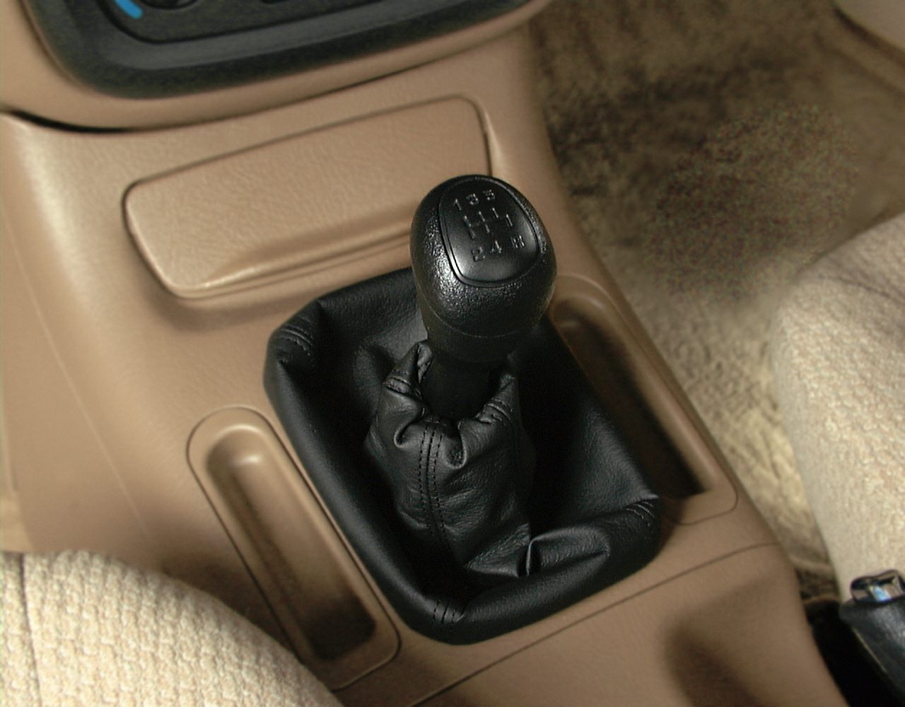 Close-up of 5-speed manual gear shift lever in beige interior