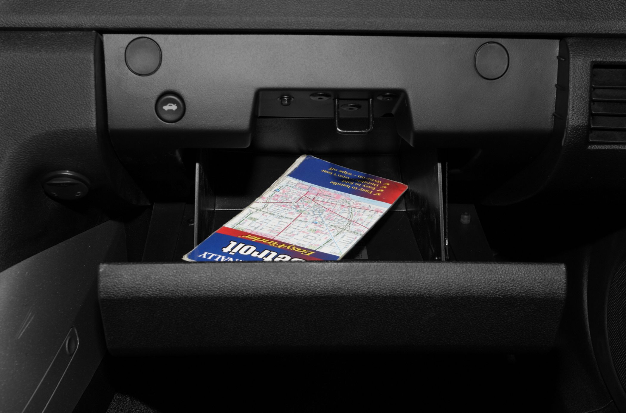 Open glove box with visible storage compartment and map inside