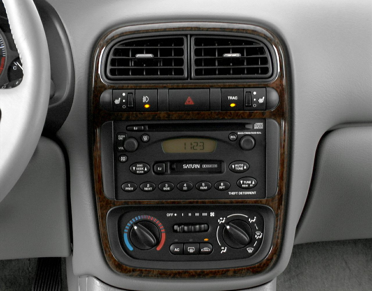 Dashboard control panel with climate and radio controls, wood grain trim