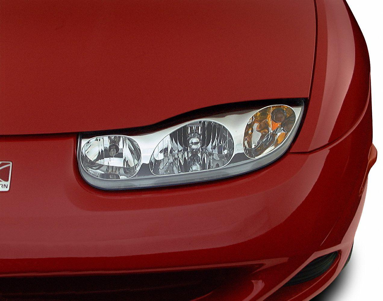 Close-up of front left headlight and red hood.
