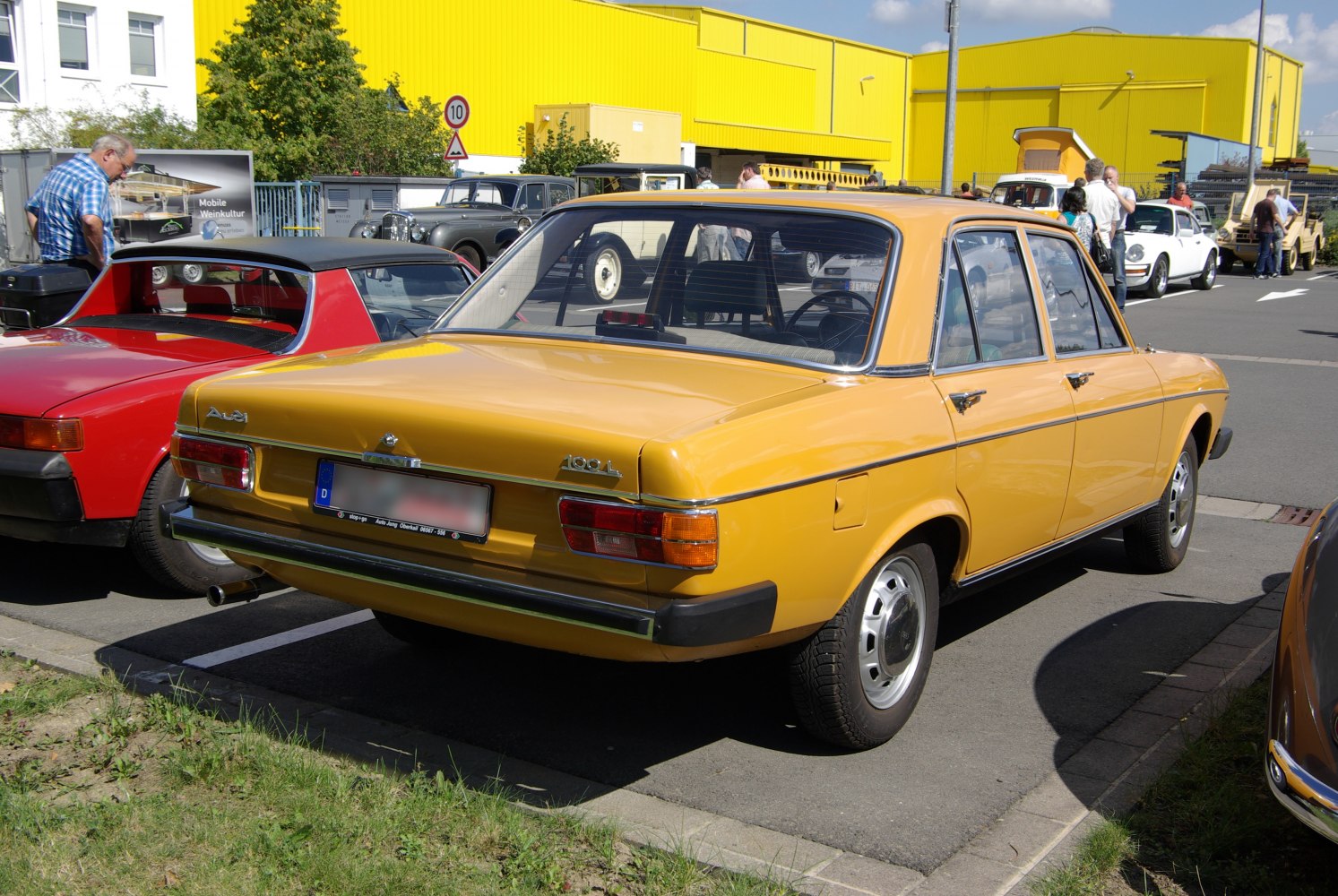 Classic yellow 1970s sedan rear with chrome trim and distinct taillights