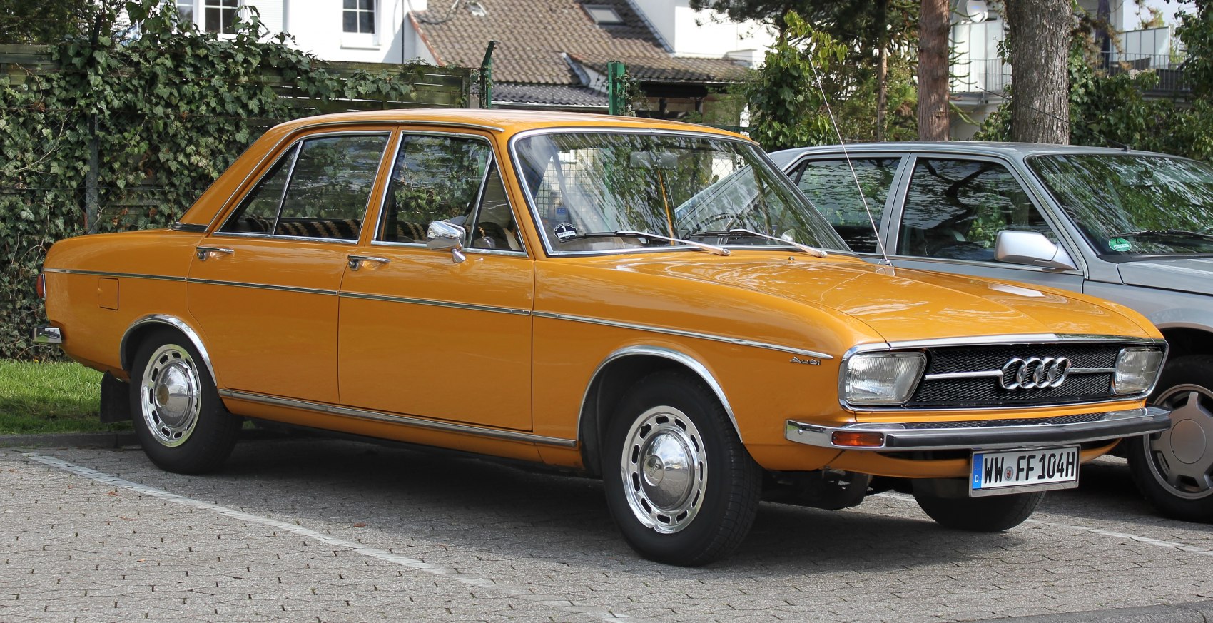 Vintage sedan with chrome side trims, round hubcaps, and rectangular headlights