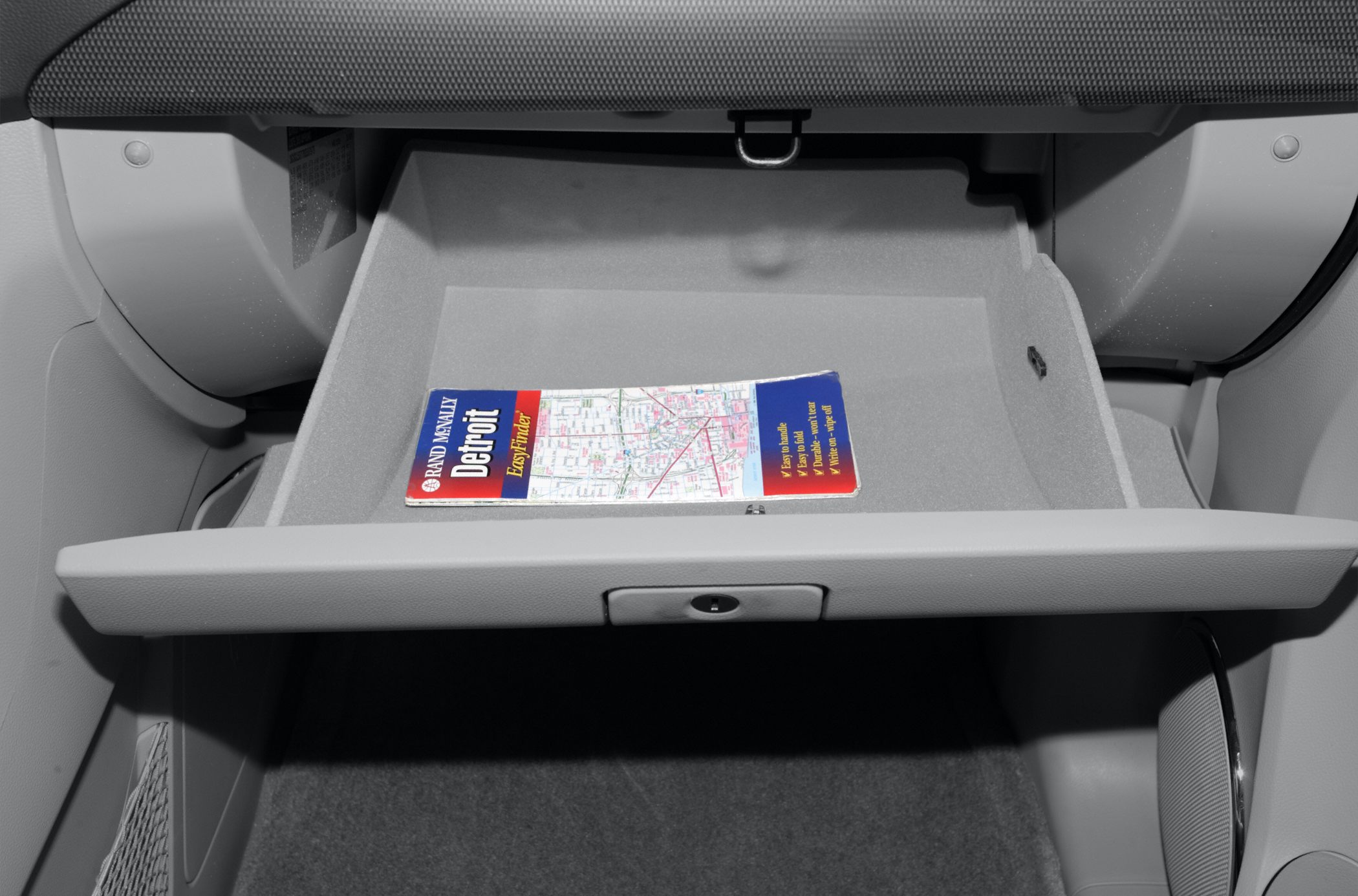 Open glove compartment with a map inside in car interior