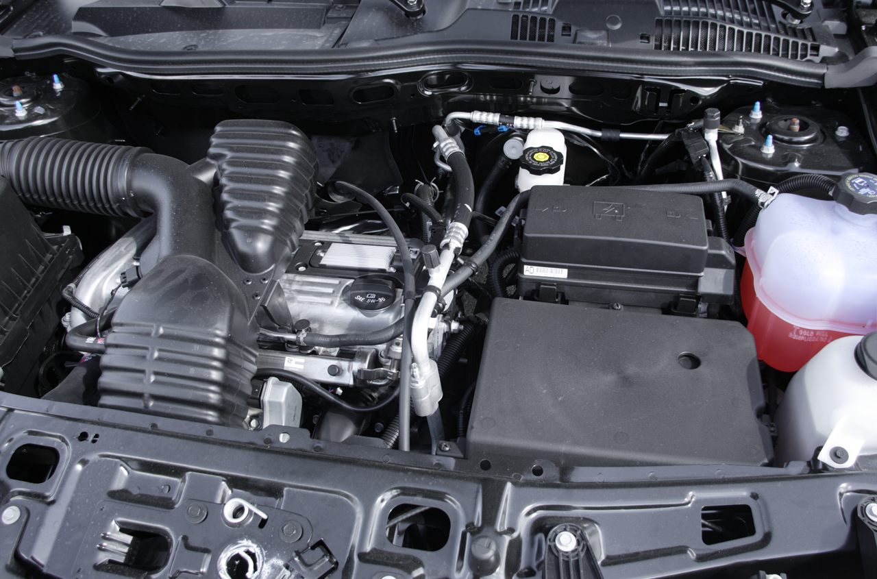 Close-up of engine bay with air intake, coolant reservoir, and battery cover