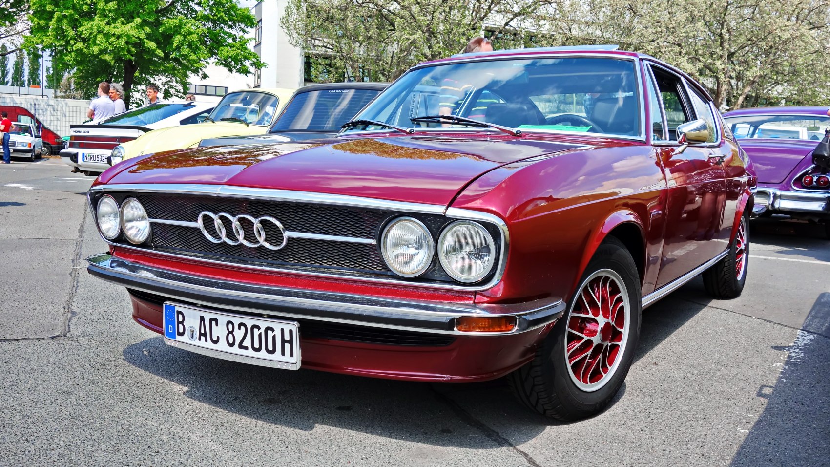 Front and side view of classic vintage coupe with dual round headlights and unique red alloy wheels