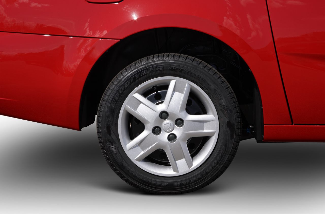 Silver alloy wheel with Goodyear tire on red car rear side