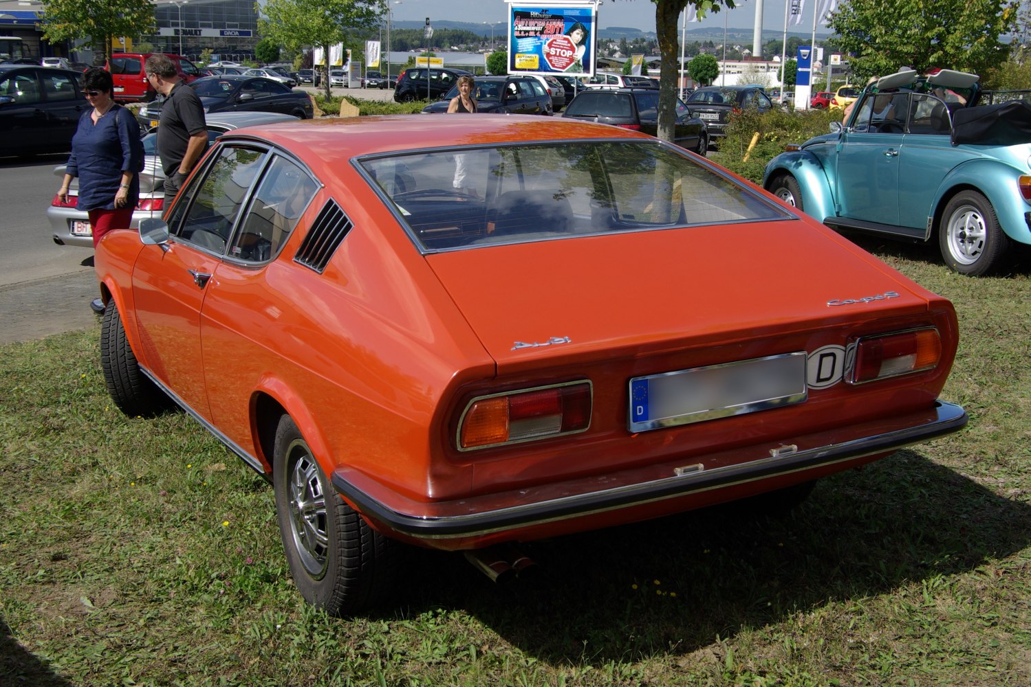 Orange classic coupe with sloped rear hatch and distinctive taillights