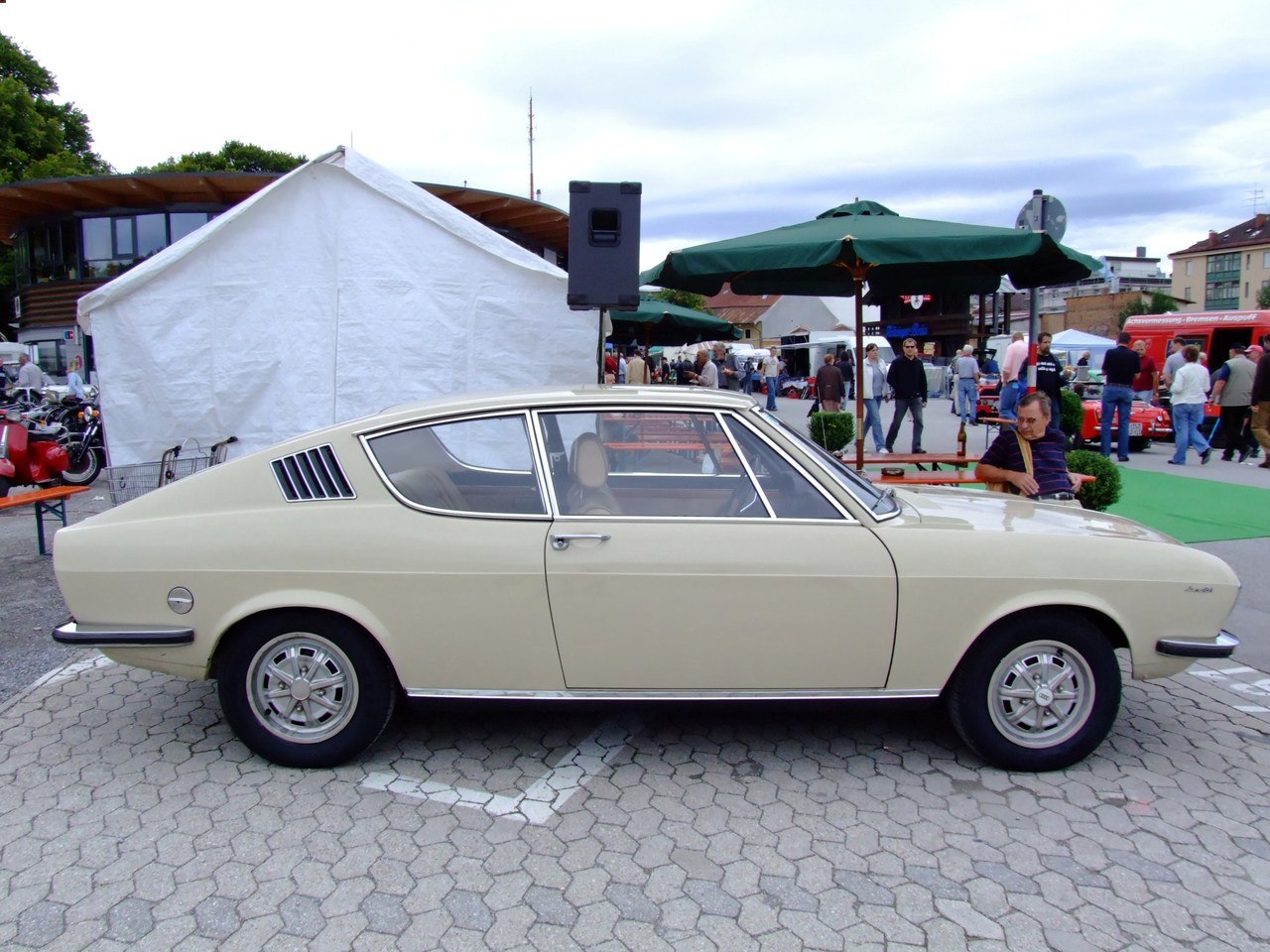 Side profile of vintage coupe with rear window vents and chrome rims