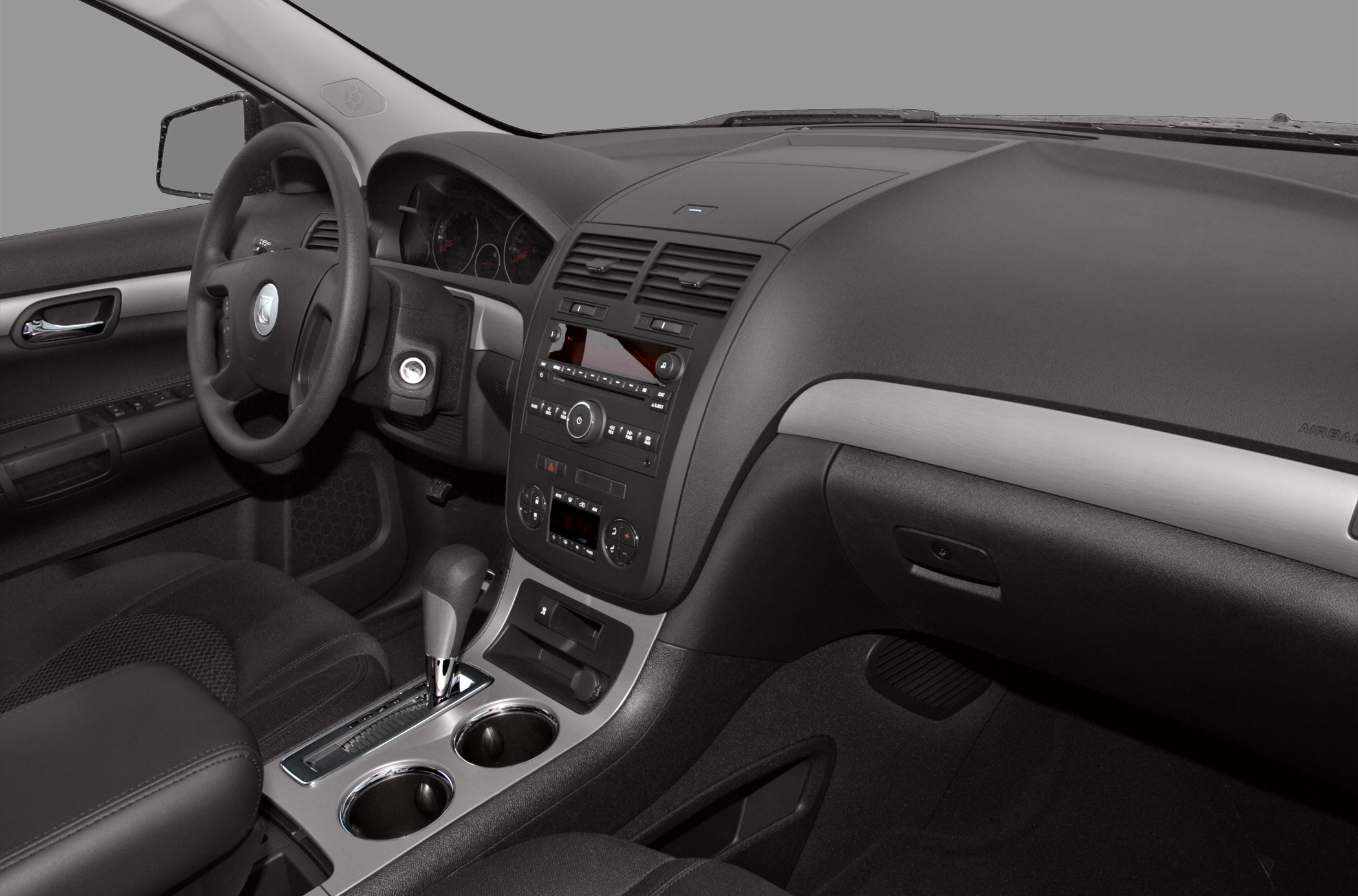 Dashboard and center console with gear shifter and cupholders.