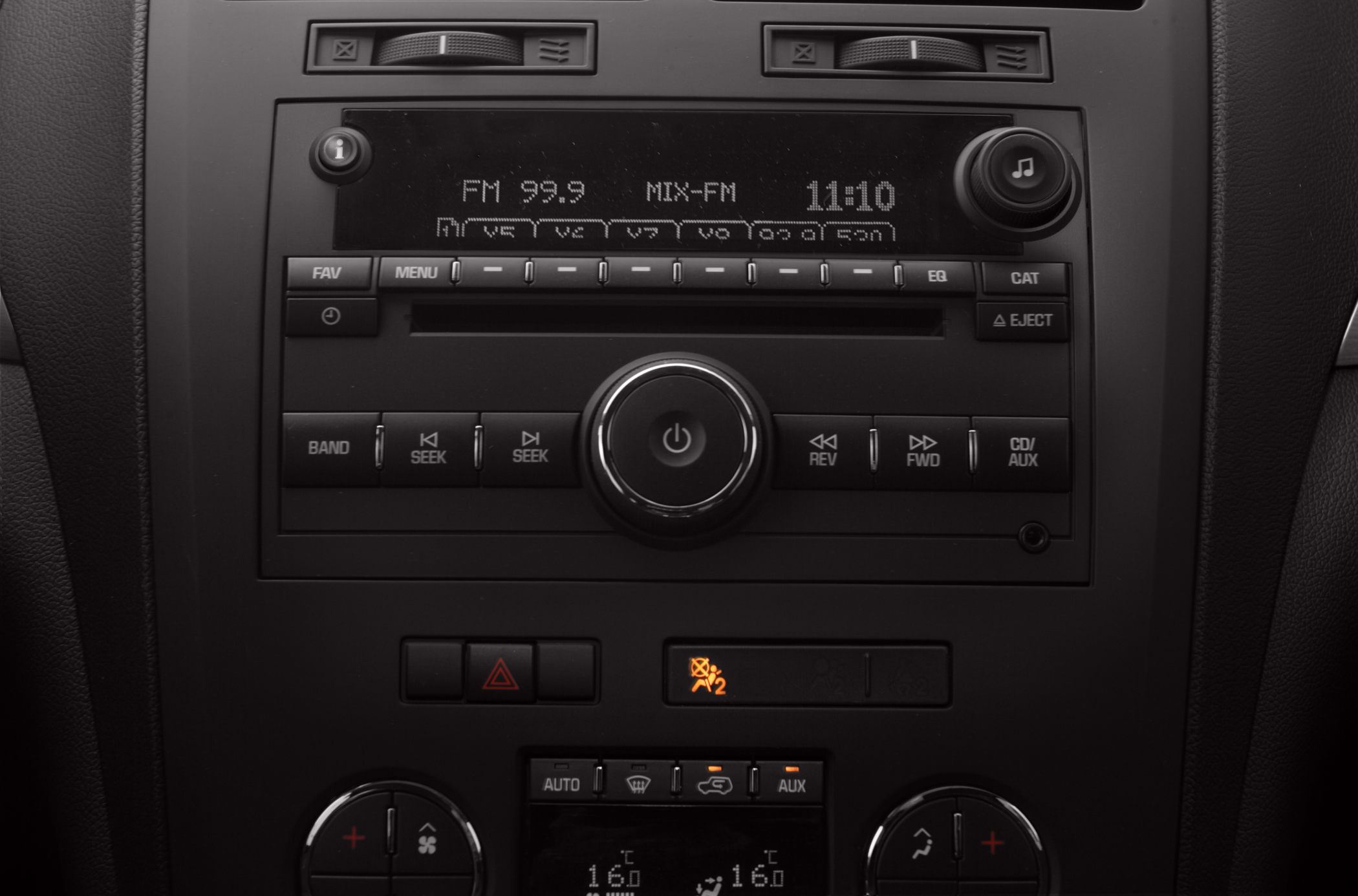 Car radio and climate control panel with FM display and temperature controls