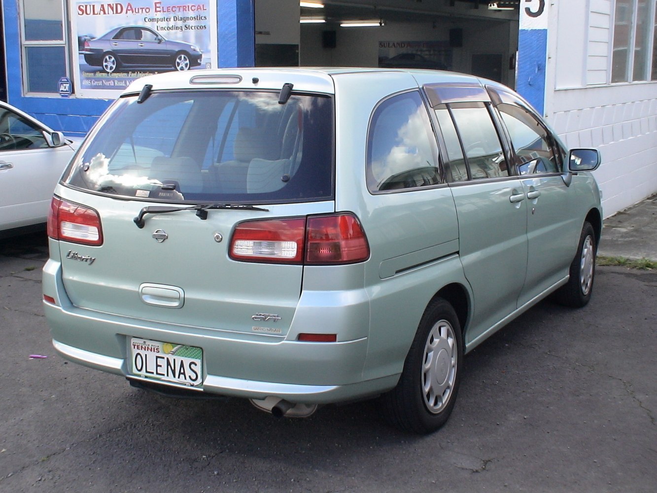 Rear and side view showing rear lights and body design of a mid-1998s minivan.