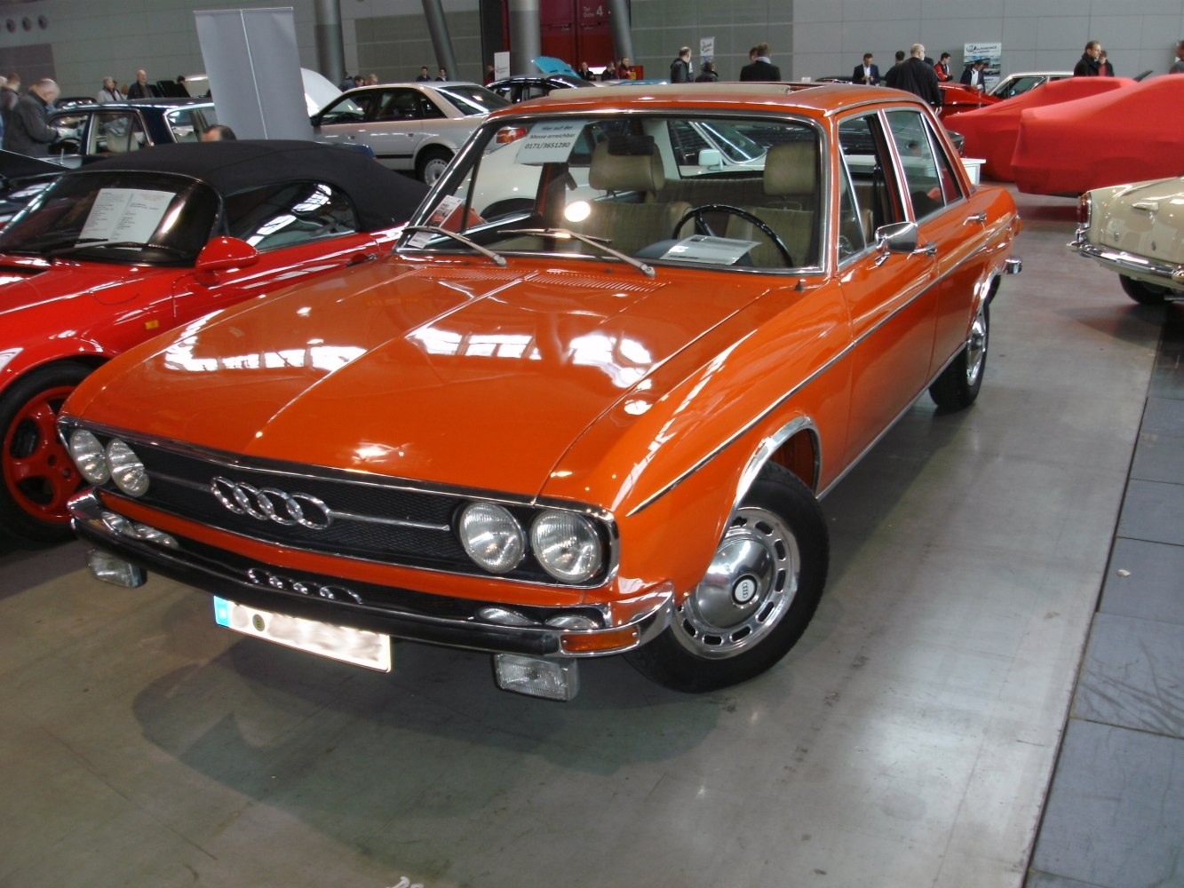 Orange vintage sedan with dual round headlights and chrome trim