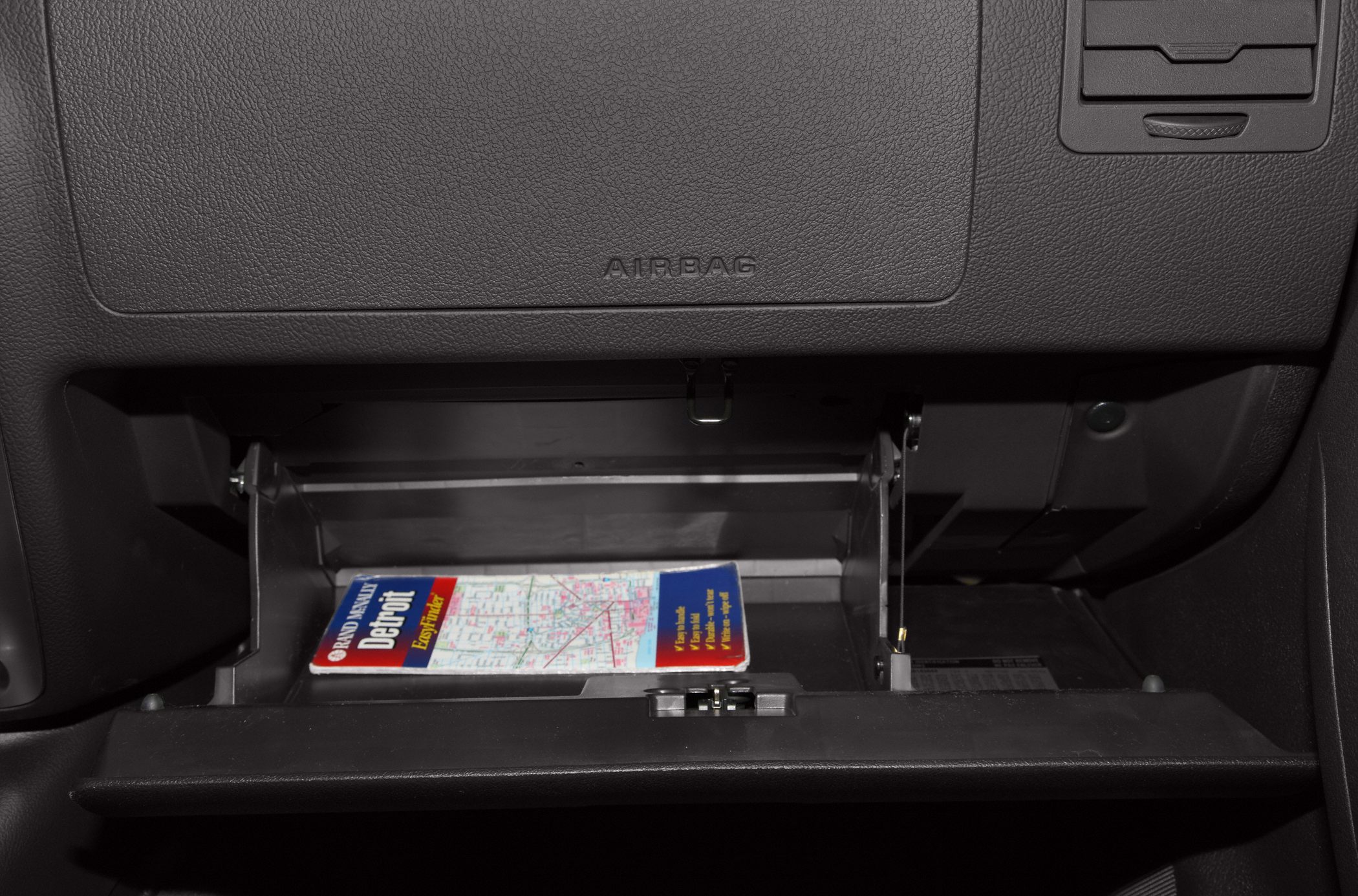 Open glove box with a map inside in vehicle interior